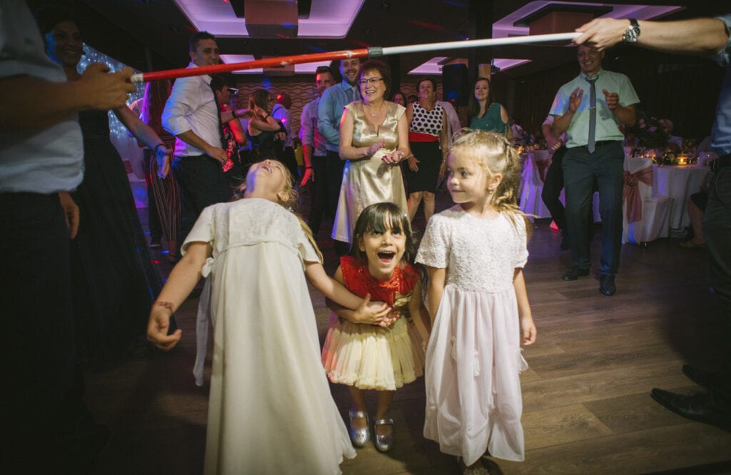 kids are playing limbo game on the dancefloor at a wedding in Budapest