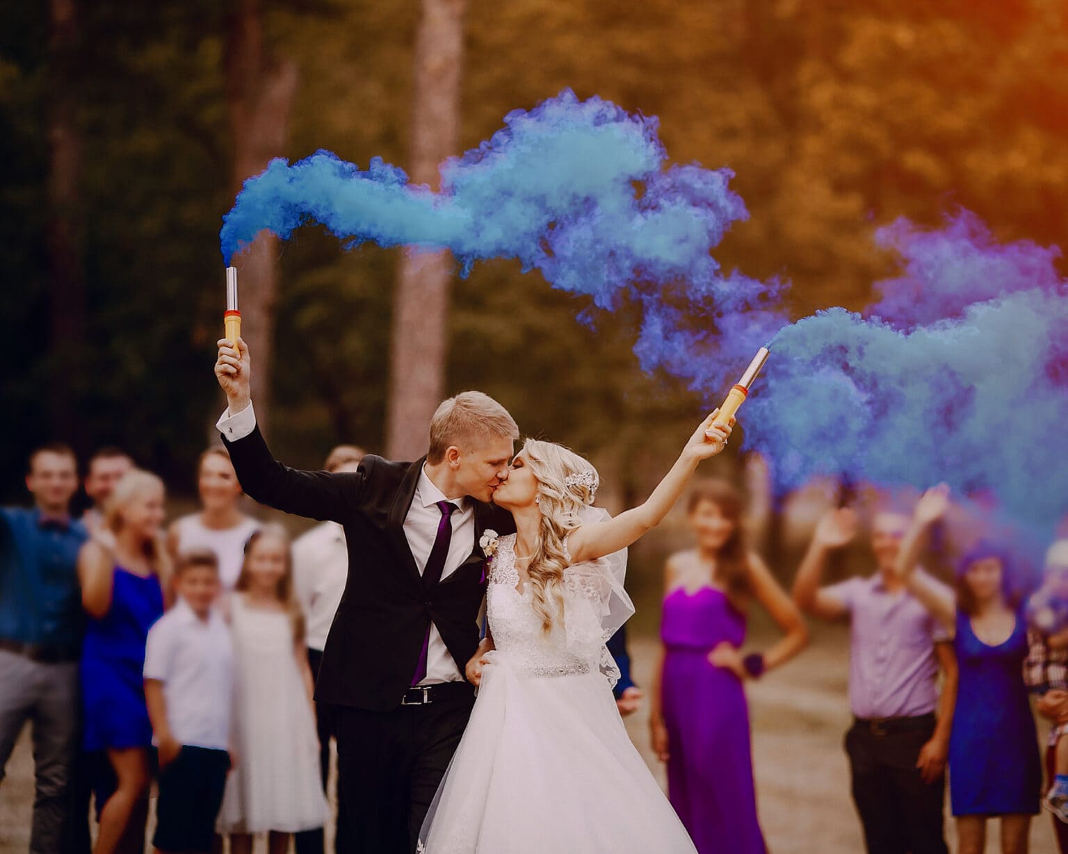 golden hour smoke bomb wedding photos with vibrant blue colour flares