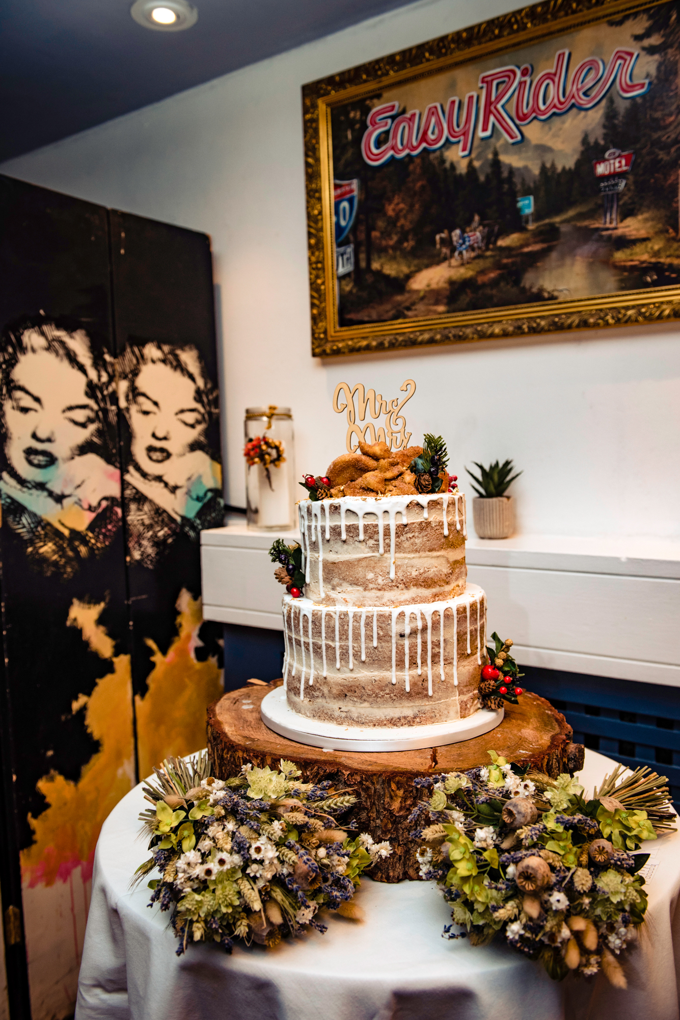 Two-tier semi-naked wedding cake with rustic florals and matching bouquets.
