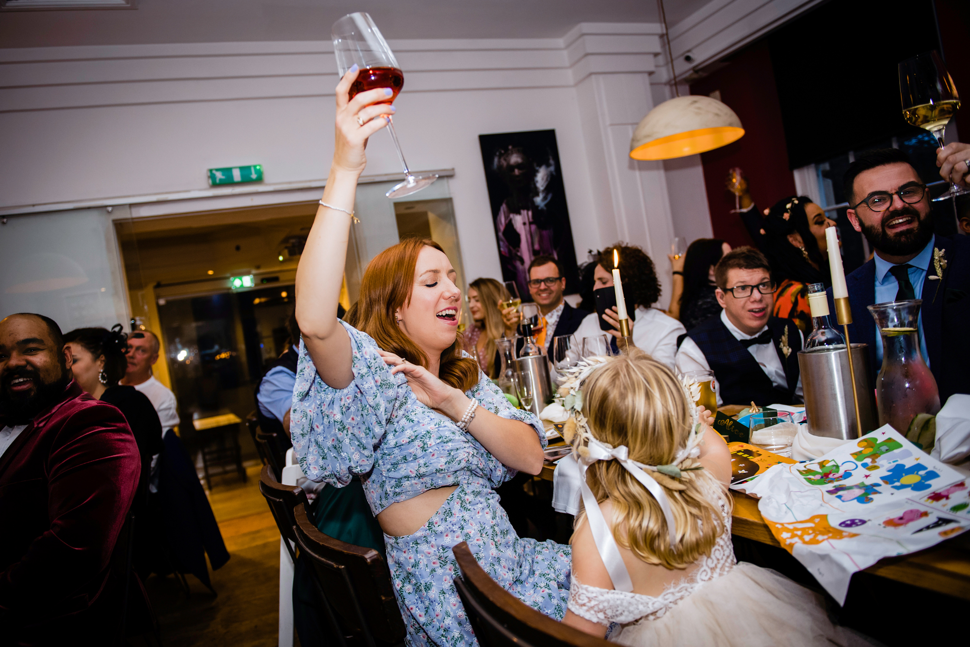 Guests raising glasses in a fun, lively wedding celebration.