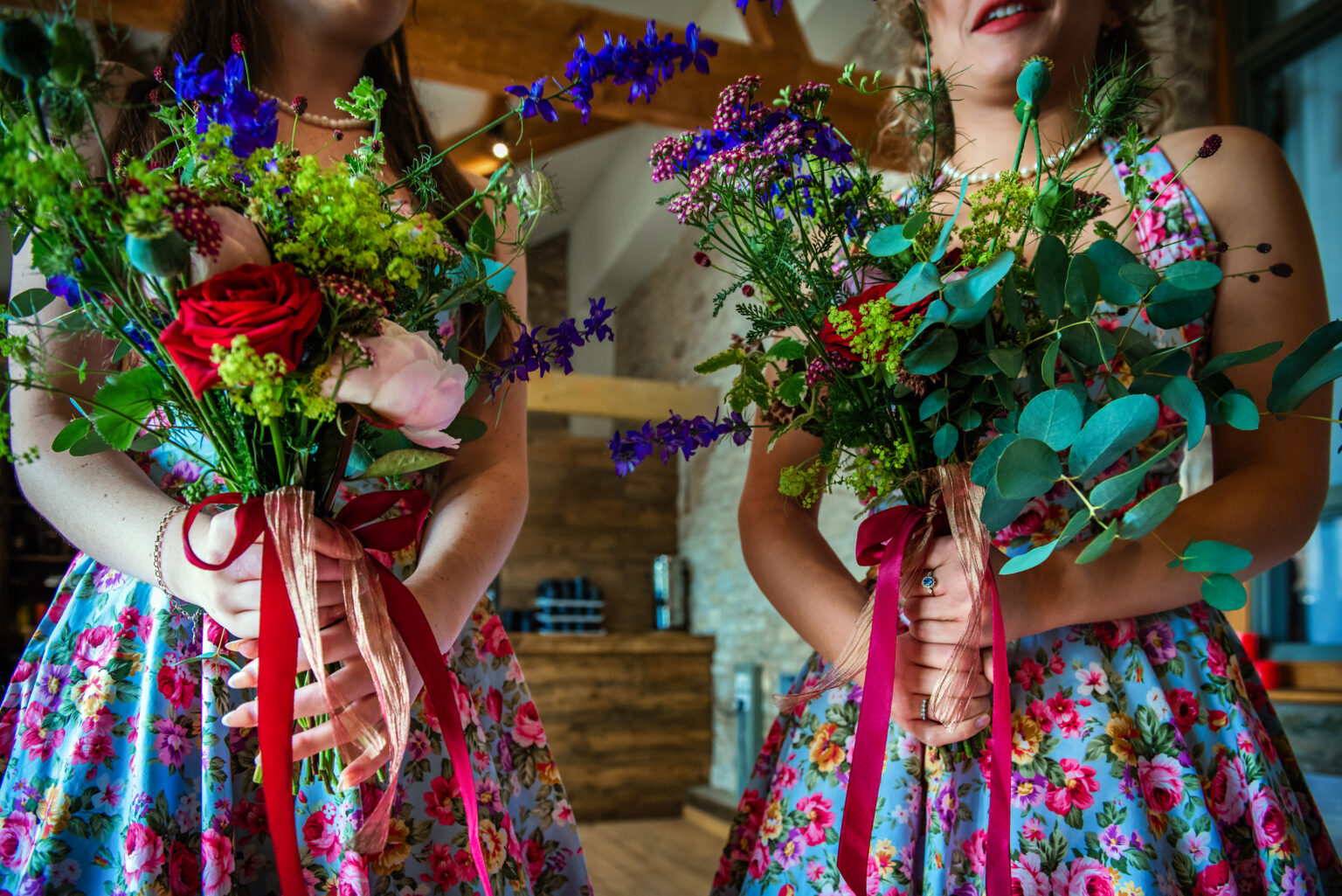 The bridesmaid are holding wildflower bouquets for a wedding at Folly Farm