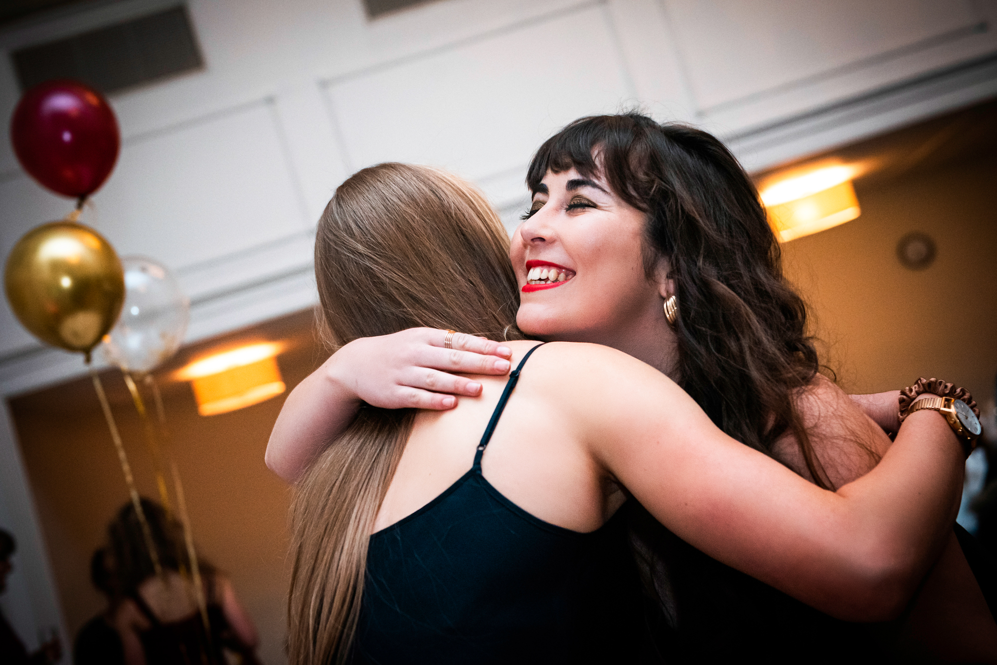 Two guests hugging during the gala dinner reception at Bristol Grand Hotel.