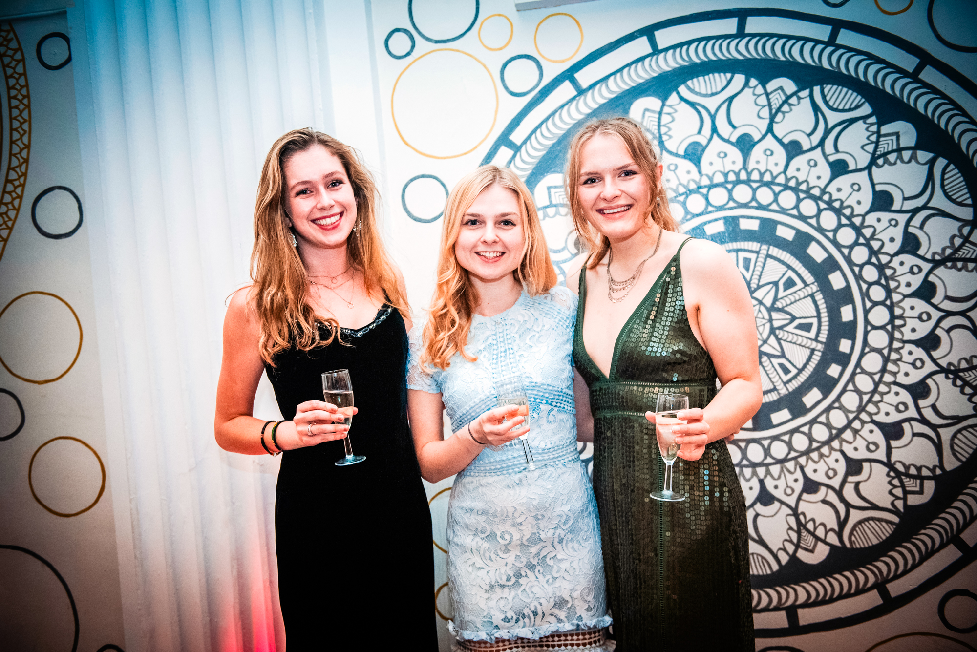 Three guests posing with champagne glasses at the Galenicals Awards gala dinner in Bristol.