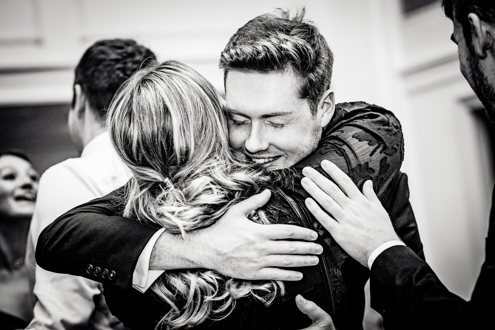 Emotional hug between guests during the Galenicals Awards celebration at Bristol Grand Hotel.
