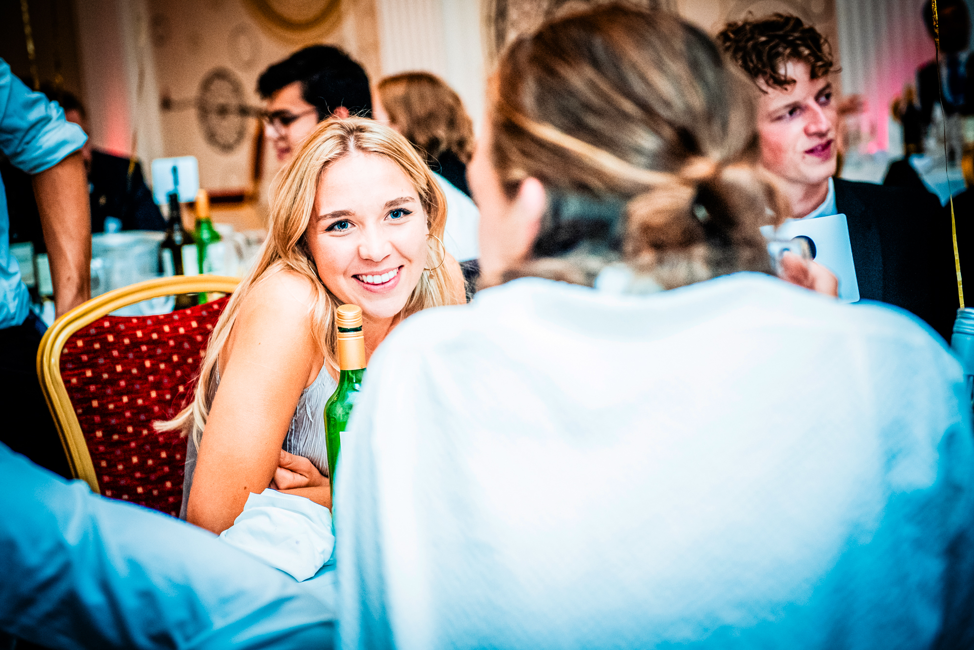 Blonde guest smiling across the table during the Galenicals Awards dinner at Bristol Grand Hotel.
