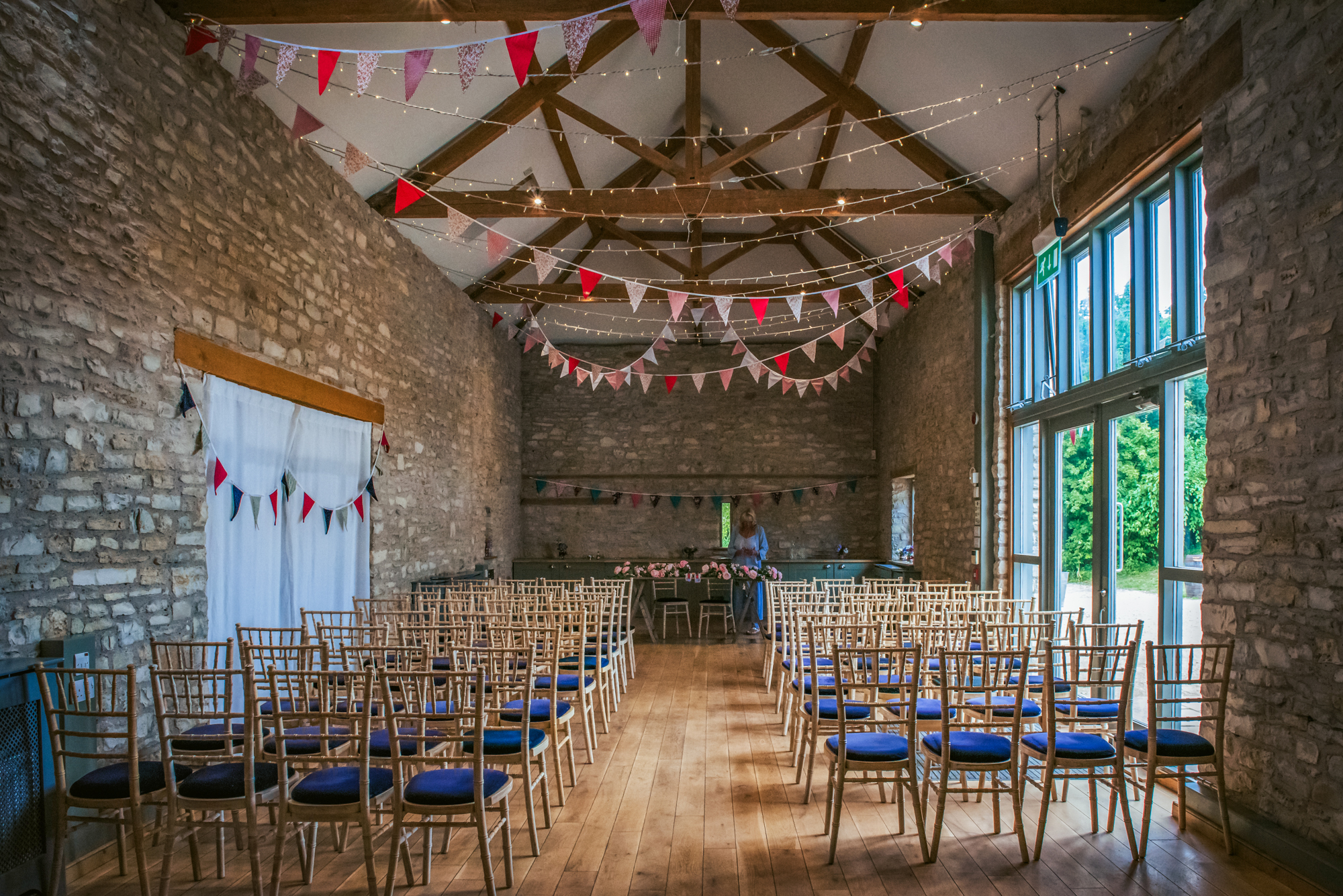 The stone-walled ceremony room is decorated with colourful bunting and fairy lights for a Scottish-inspired celebration.