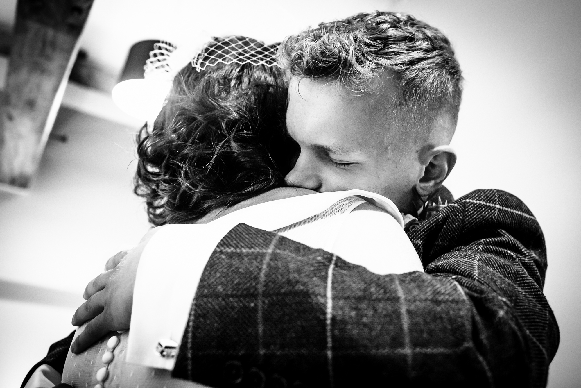 A heartfelt hug is shared before the ceremony, with eyes closed and emotions running deep.