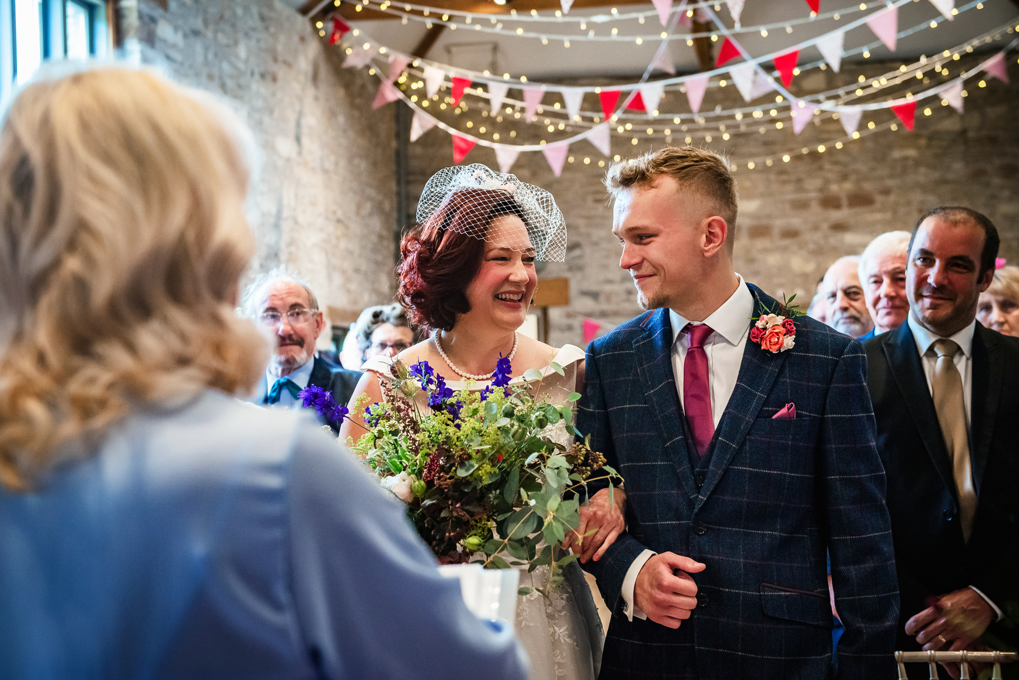 The bride and her son share a warm smile as they reach the celebrant at the front.