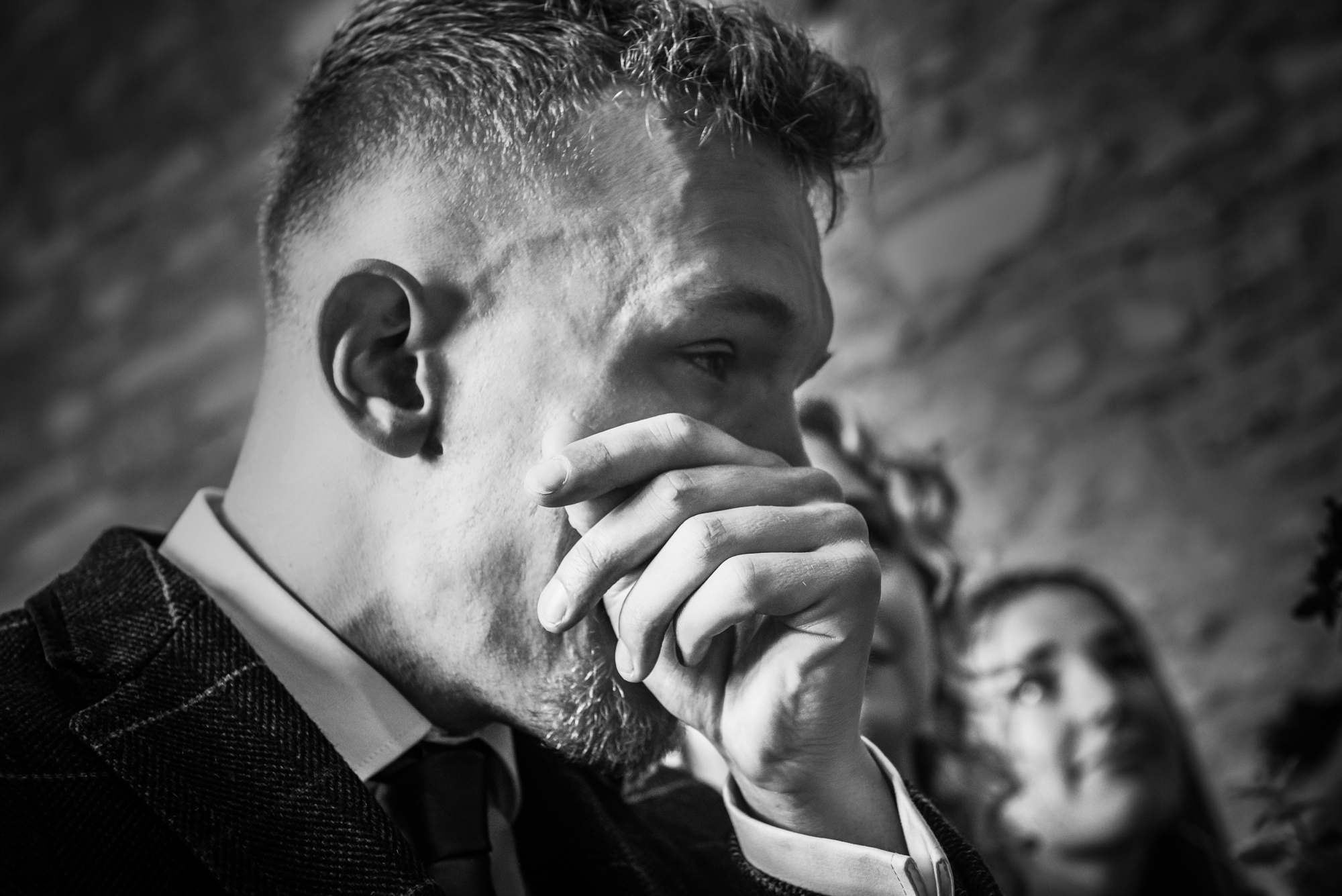 The bride's son wipes his eyes during an emotional moment of the ceremony inside the stone barn.