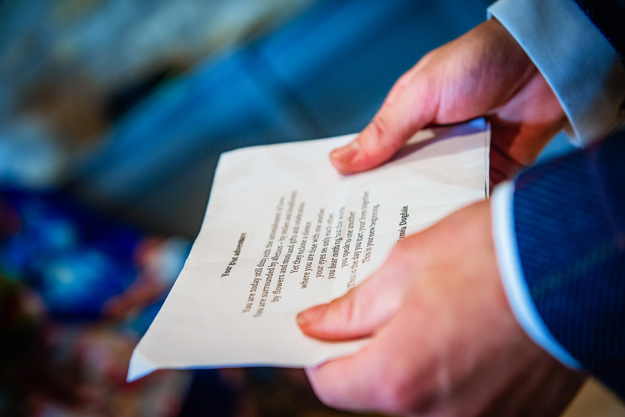A crumpled printed wedding reading is held tightly between both hands during the ceremony.