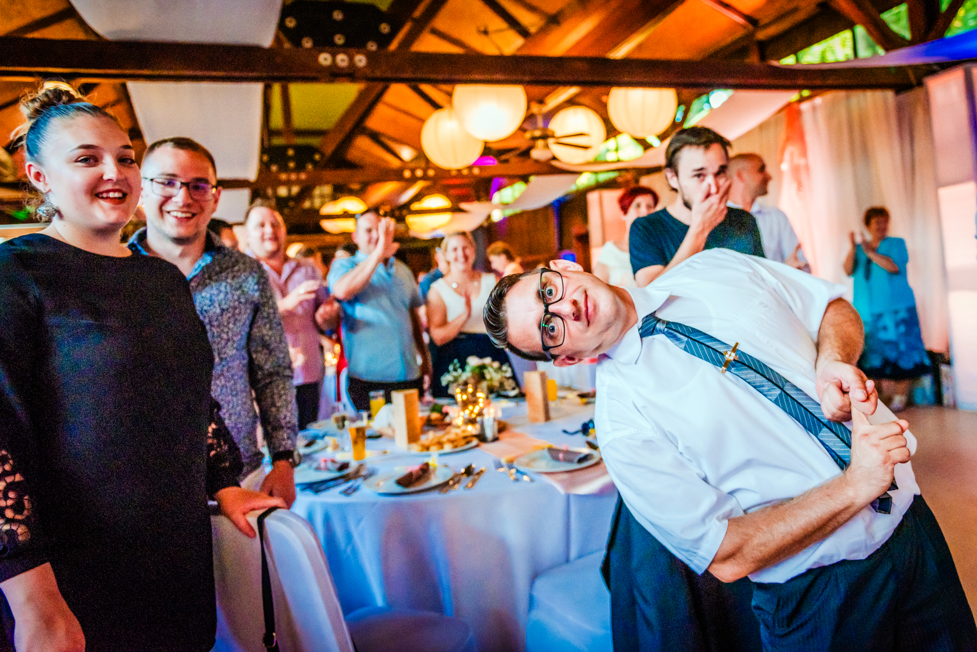 Wedding guests reacting and laughing during lively reception game at Csónakház wedding venue in Budapest.
