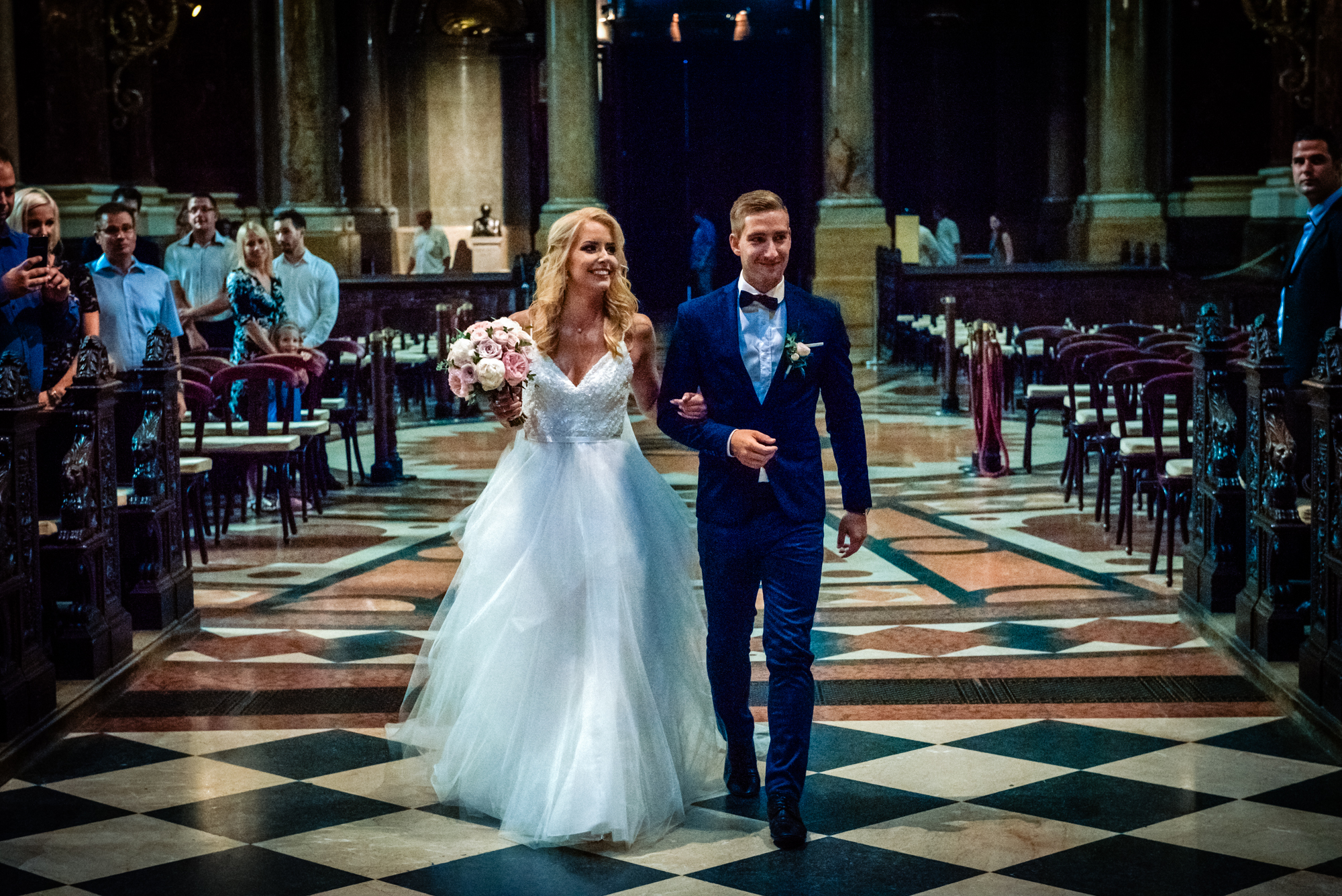 The bride walking through the grand interior of St Stephen’s Basilica during the wedding ceremony in Budapest.