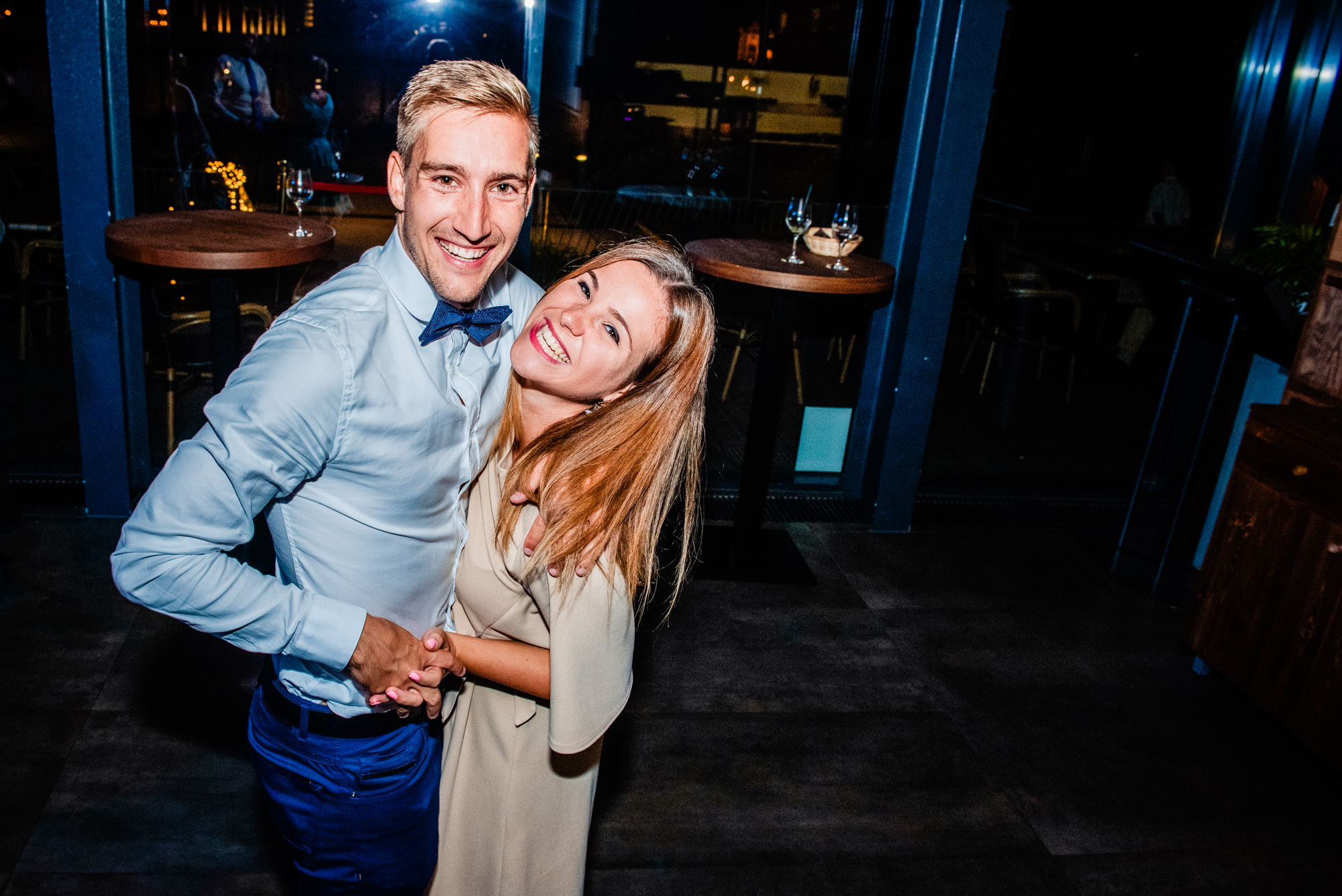 Smiling wedding guests dancing together at modern Budapest wedding reception venue.