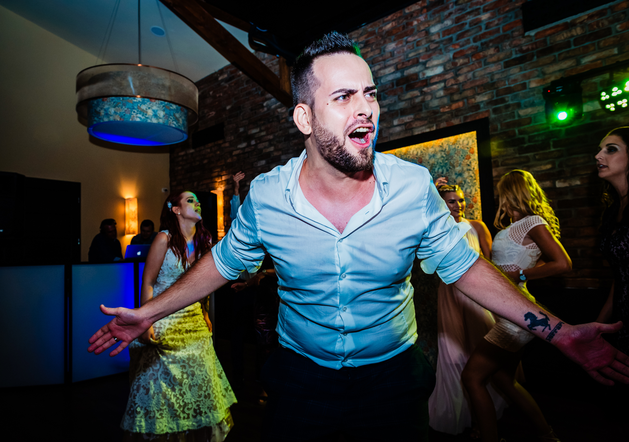 Groom sings along enthusiastically while dancing among guests at the reception.