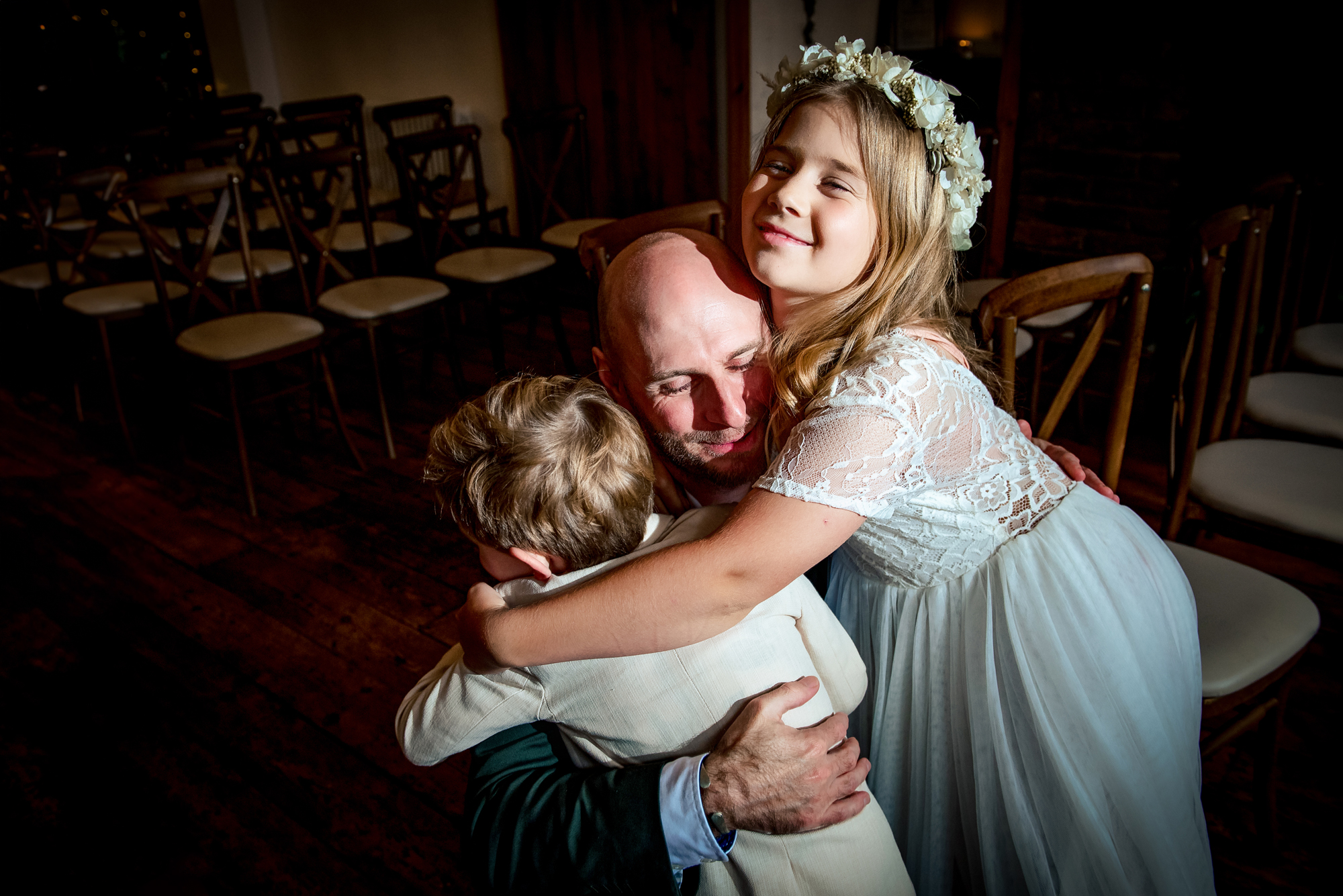 Flower girl and boy hugging the groom during intimate wedding ceremony in Bristol venue.