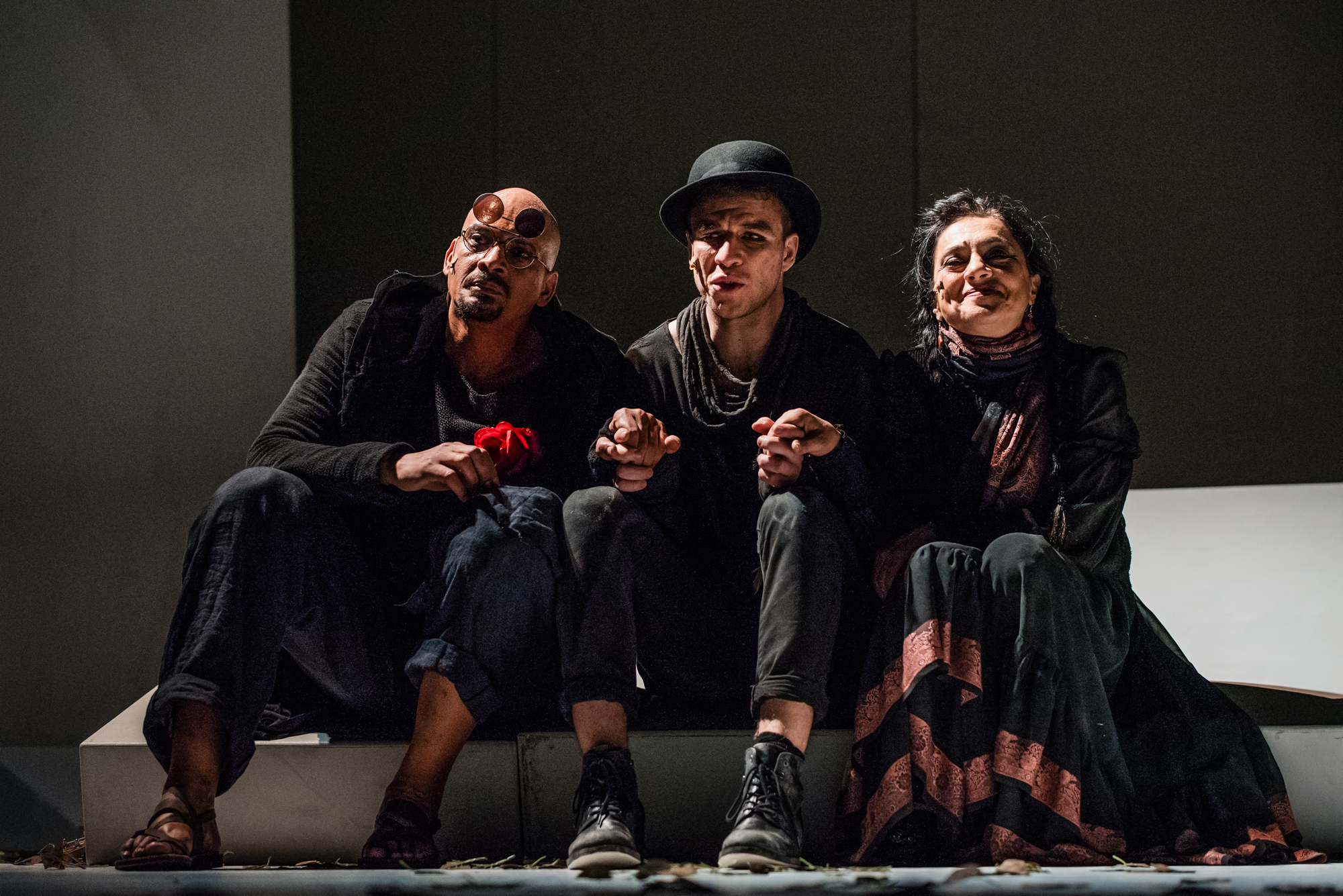 Three performers sit together on stage during closing scene of Frida Kahlo theatre production.
