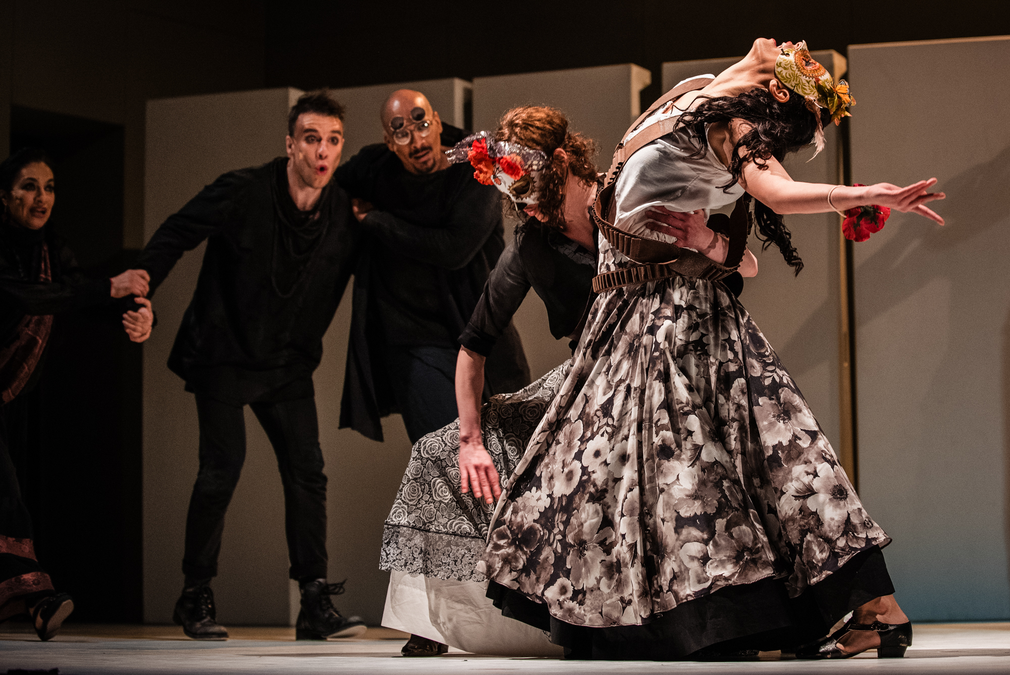 Masked performers and dancers move dramatically across stage during Frida Kahlo musical theatre production.