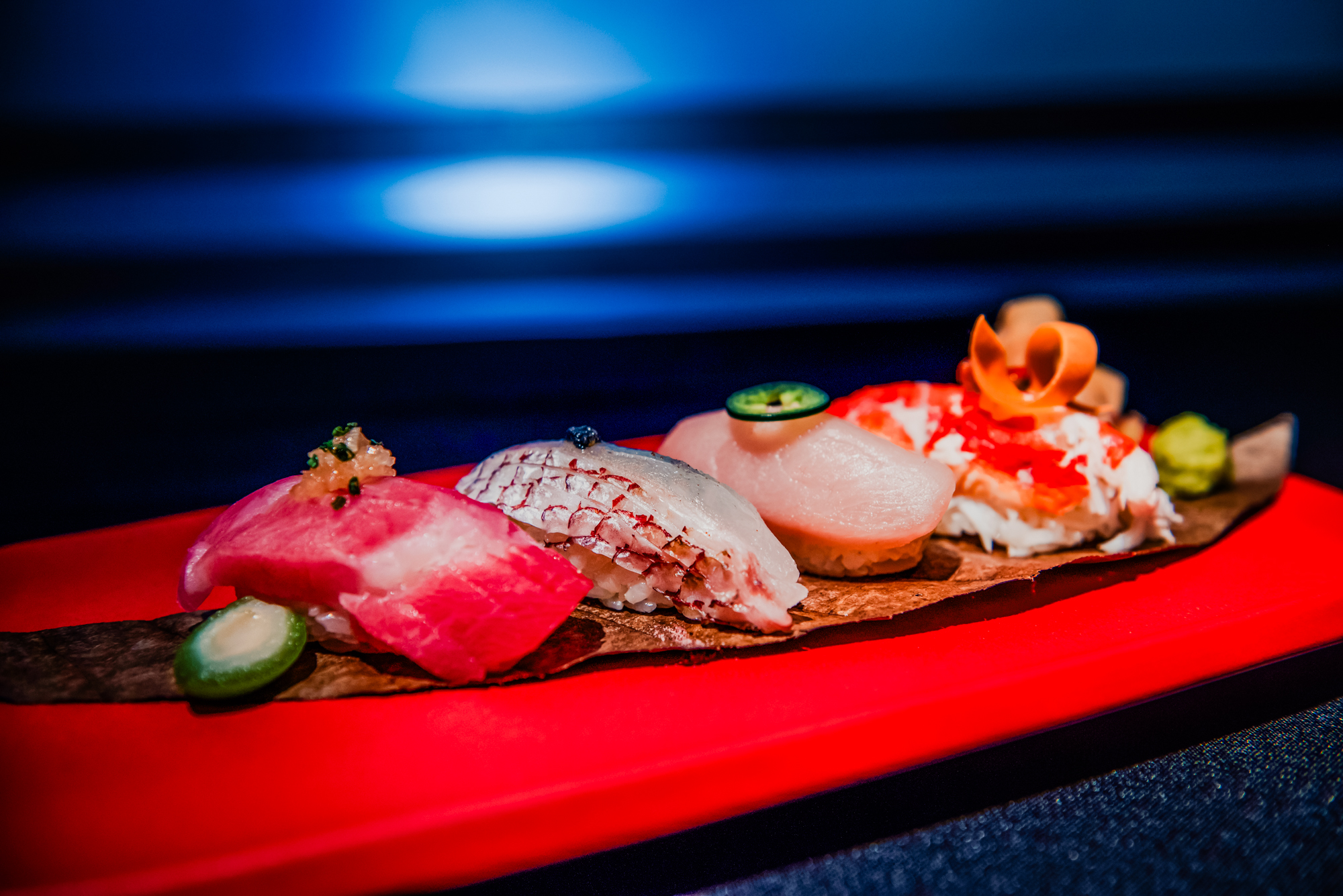 Side view of premium nigiri selection with fresh seafood and Japanese garnishes.