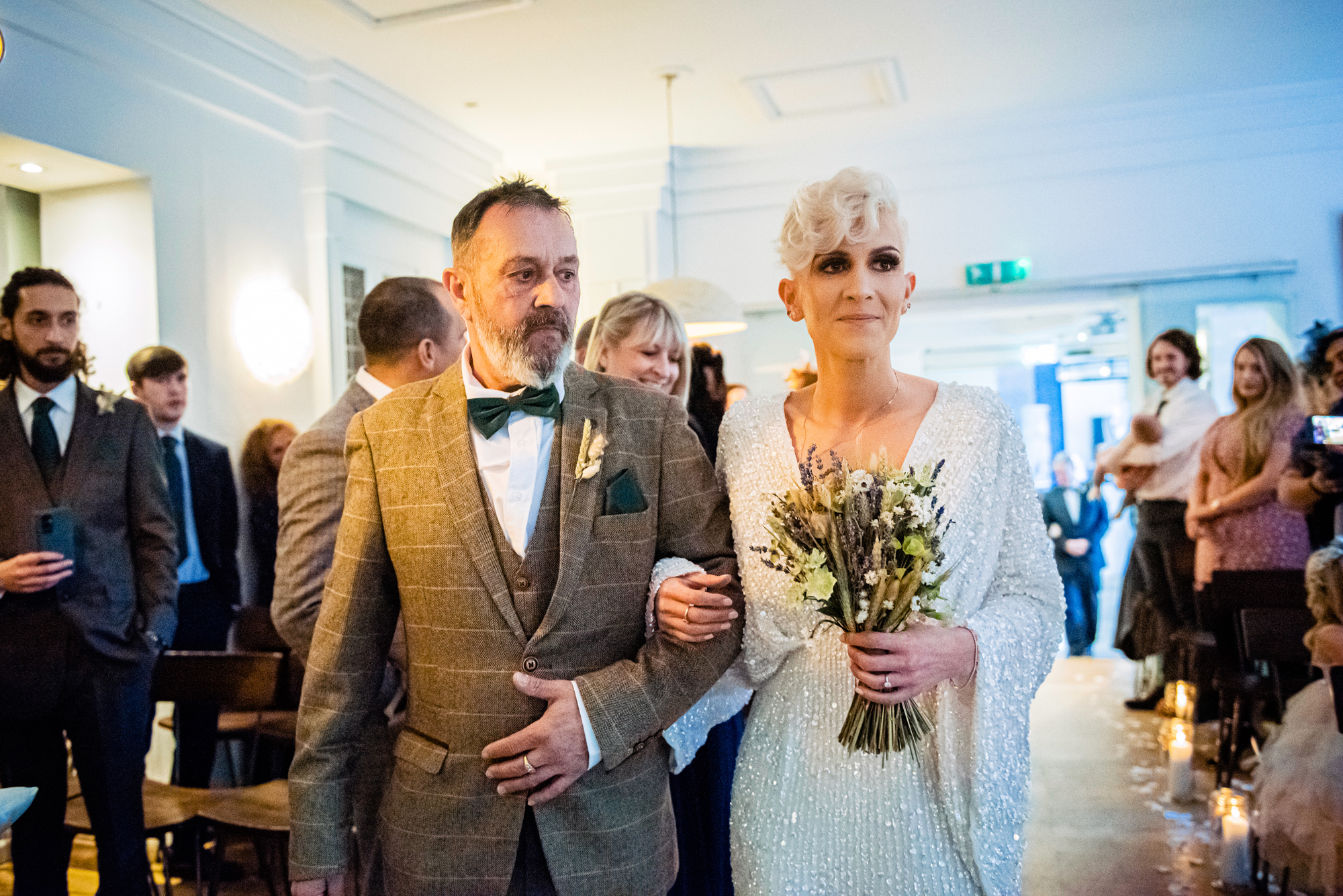 Bride walking down the aisle with her father at The Square Club Bristol, holding a dried wildflower bouquet.