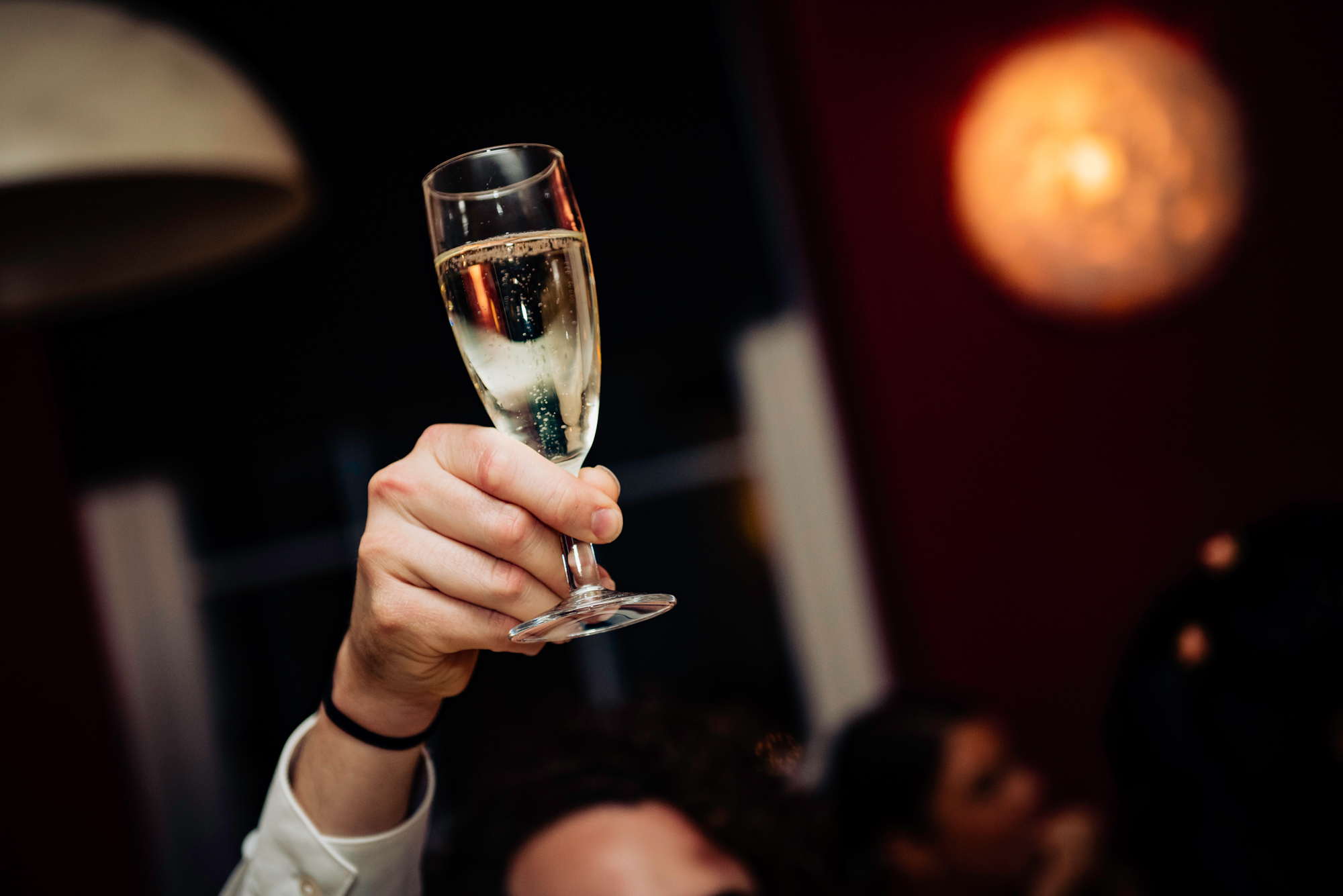 Close-up of a champagne glass raised for a celebratory wedding toast.