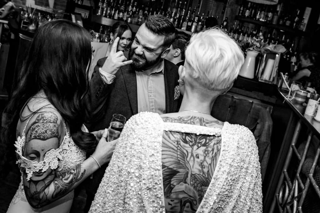Guest joking with the brides on the dance floor, captured in a candid, fun moment.