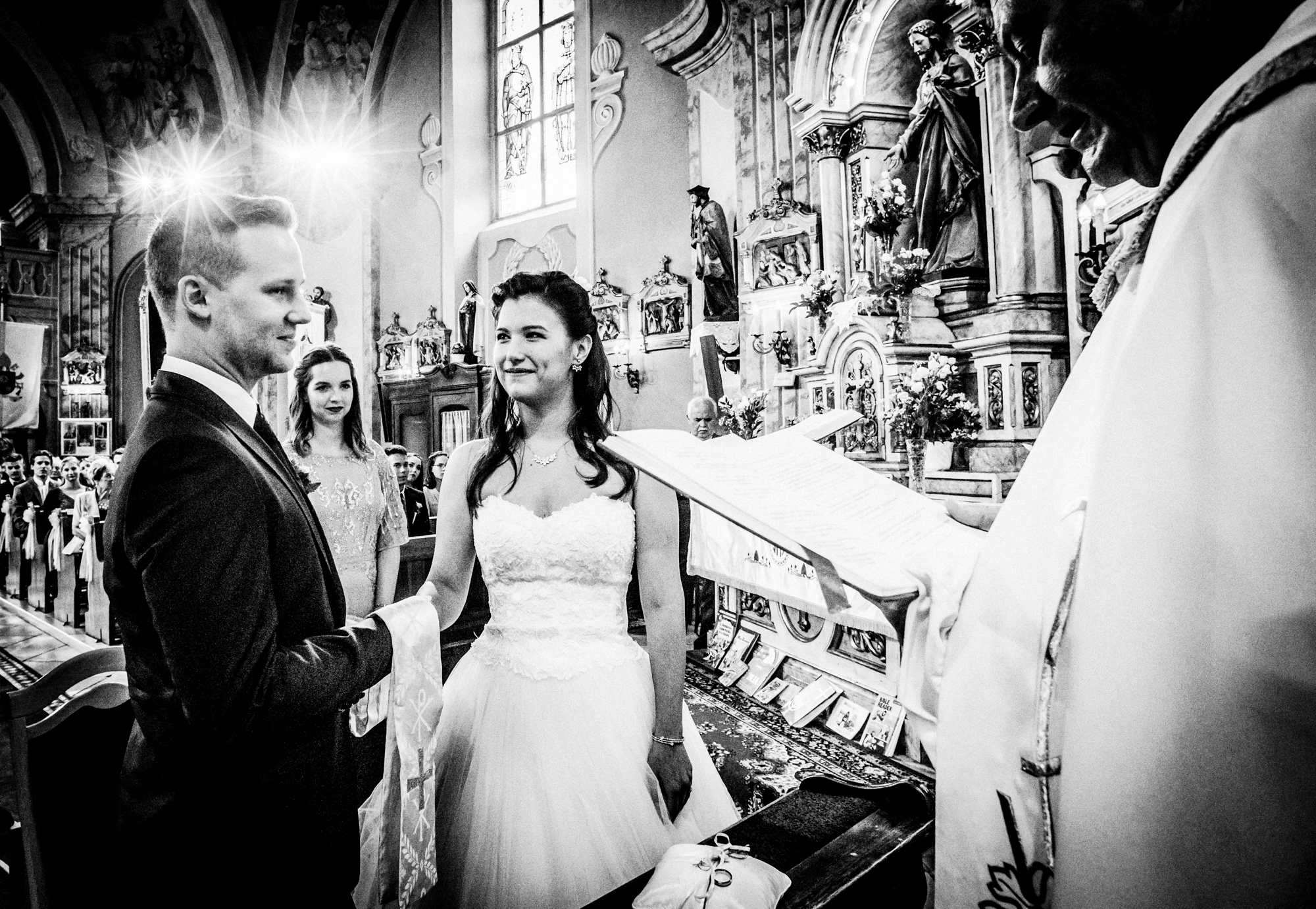Bride and groom exchanging vows during a Catholic church wedding ceremony in Hungary.