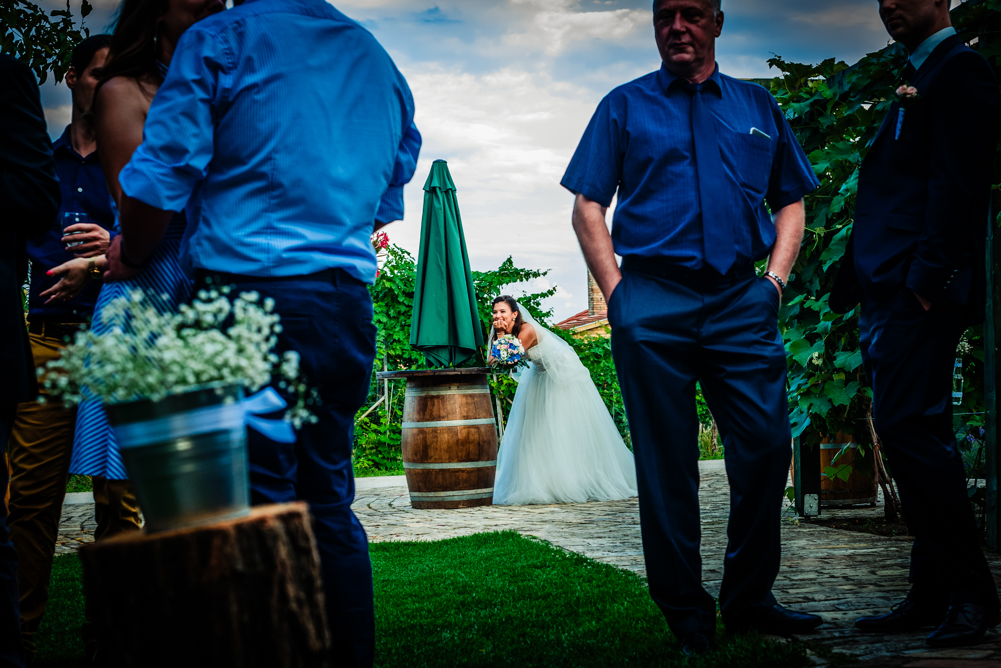 Bride laughing in the background during vineyard reception candid photograph in Hungary.