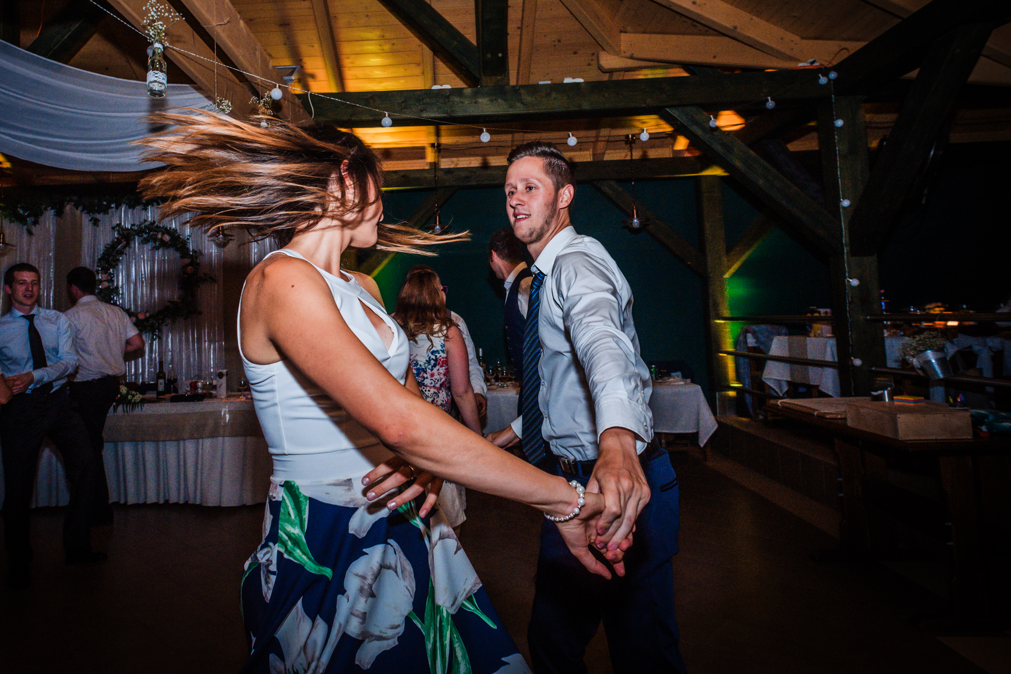 Wedding guests dancing energetically during evening reception at rustic Hungarian vineyard wedding.