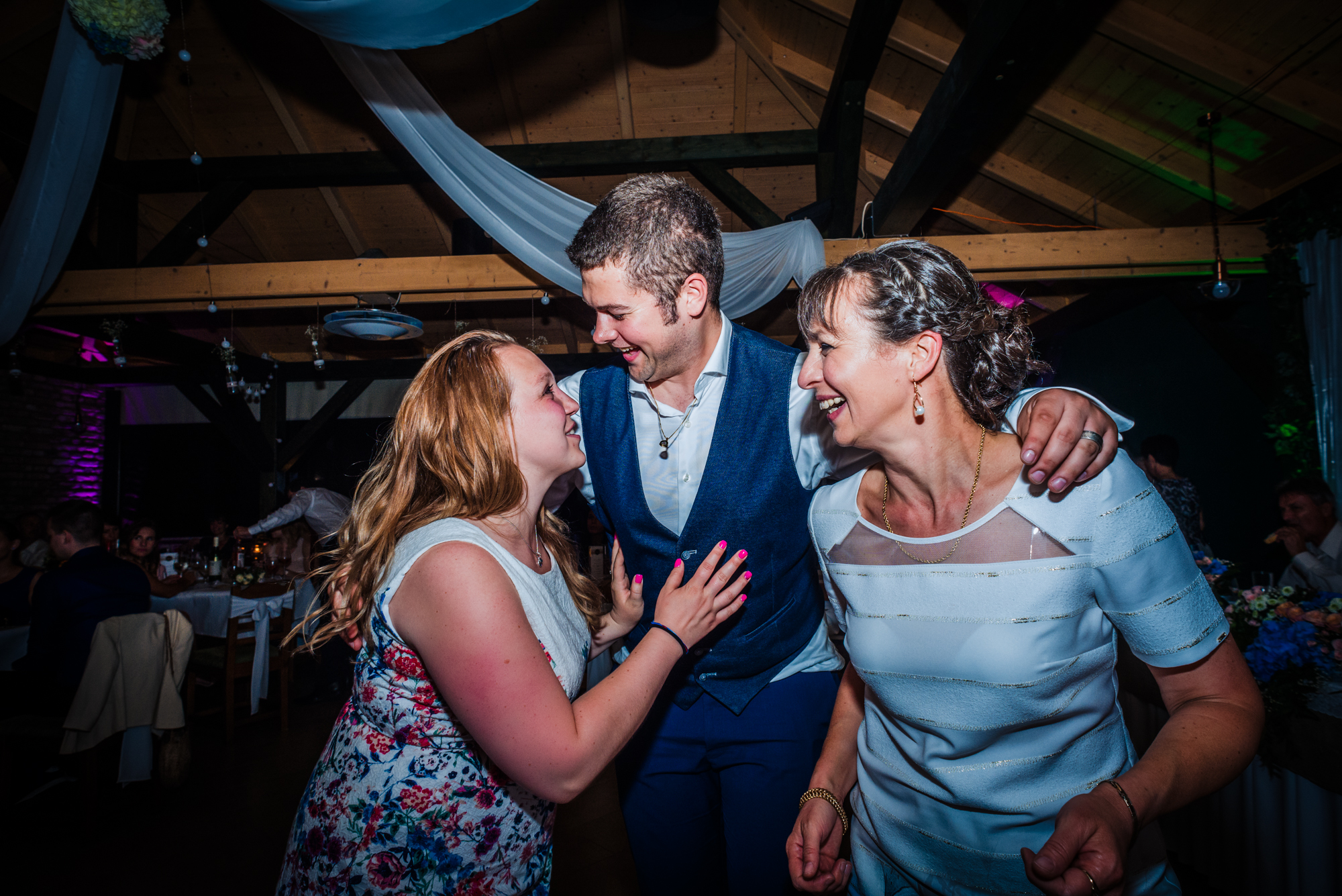 Wedding guest dancing with family members during joyful wedding reception celebration in Hungary.