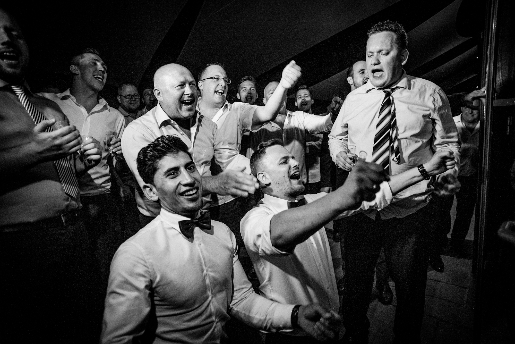 Guests cheering and dancing during emotional wedding party.