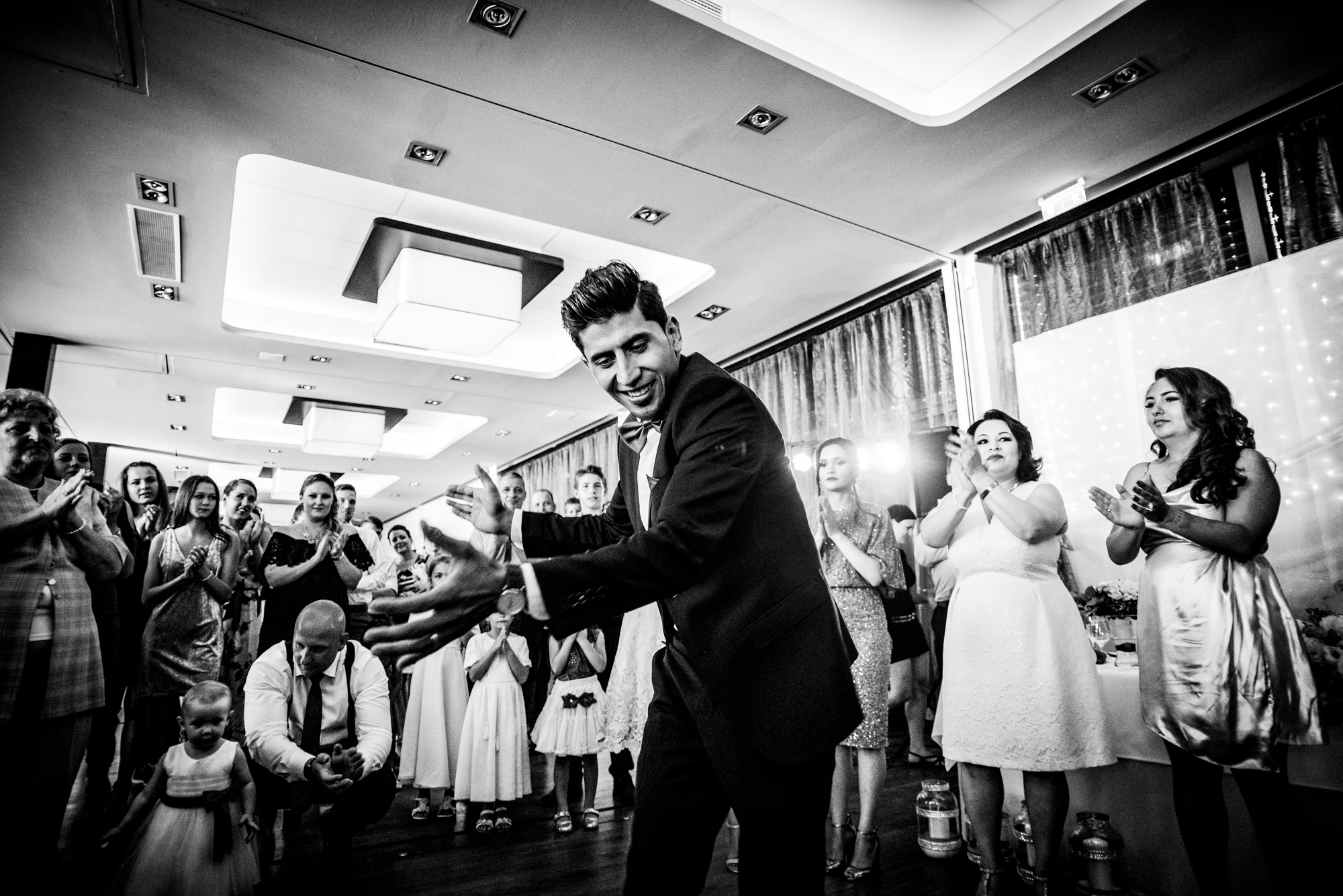 Wedding guest dancing surrounded by guests, high energy moment.