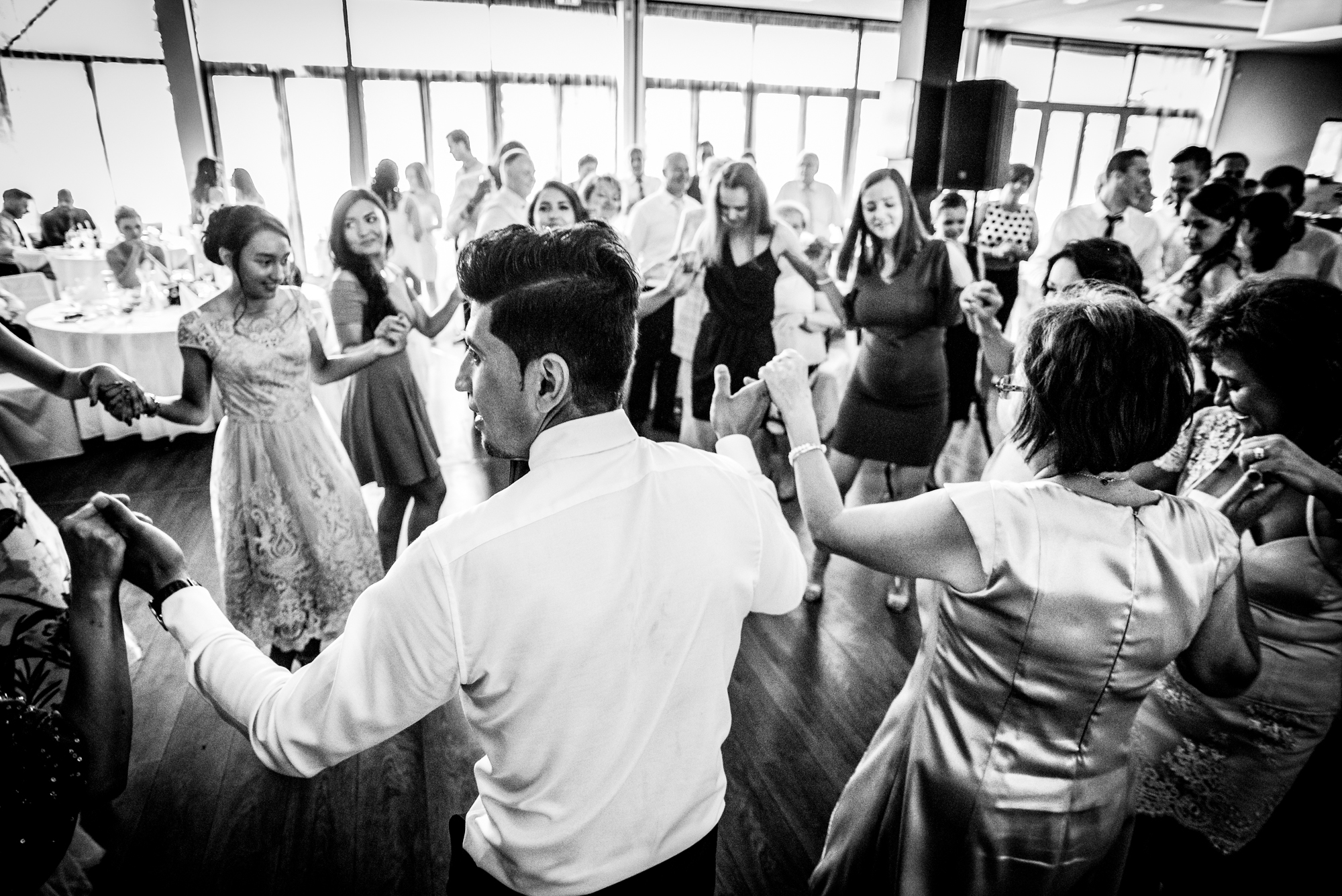 Guests dancing together in a circle at a wedding party.