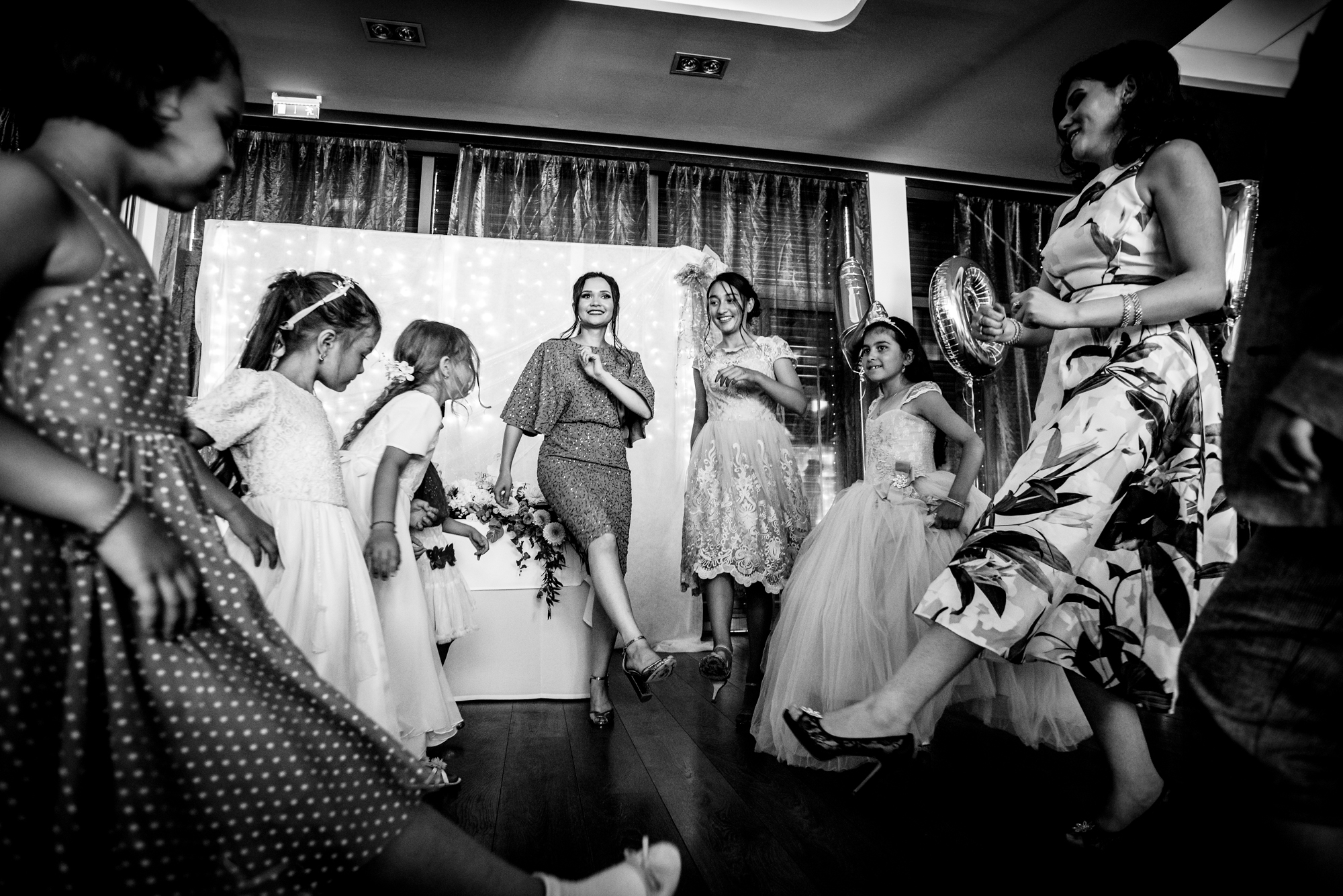 Guests dancing together in circle formation at a wedding reception at Öbölház, Budapest.