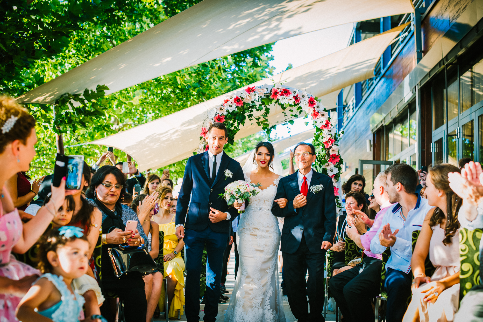 Bride and groom walking down aisle with guests applauding at Öbölház Budapest wedding.
