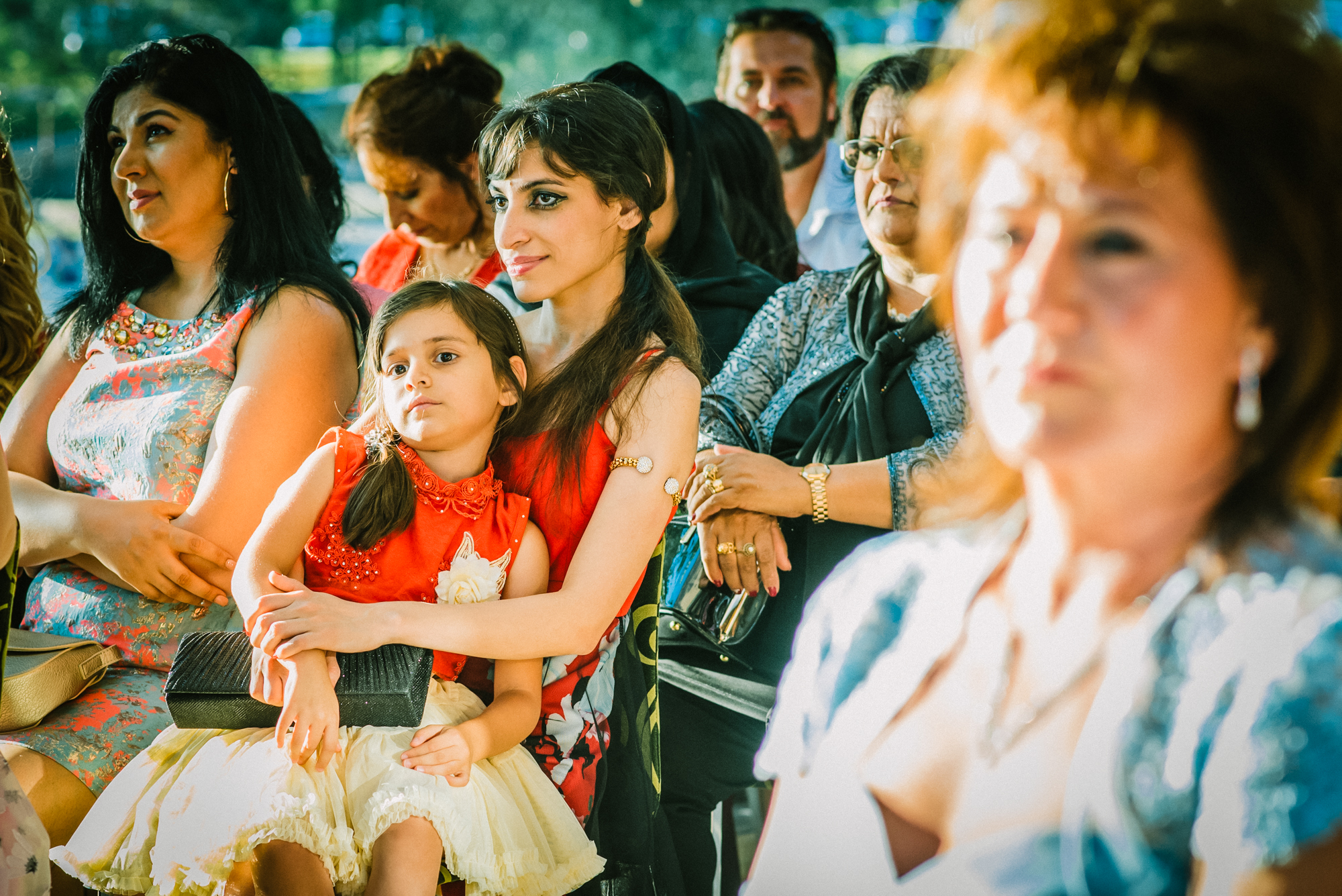 Guests watching ceremony closely, emotional expressions during multicultural wedding in Budapest venue.