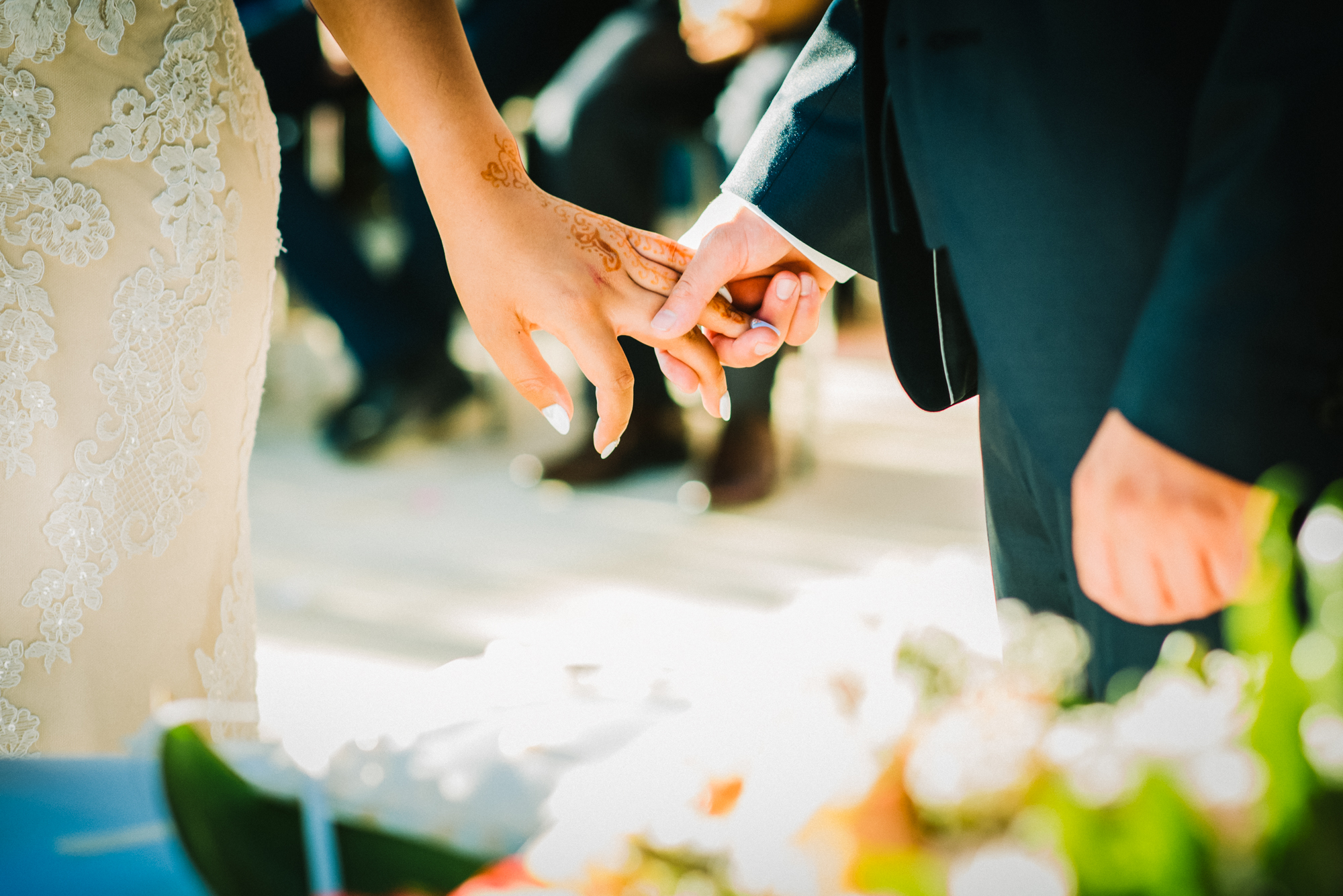 Bride and groom holding hands with henna details visible during Budapest wedding ceremony.