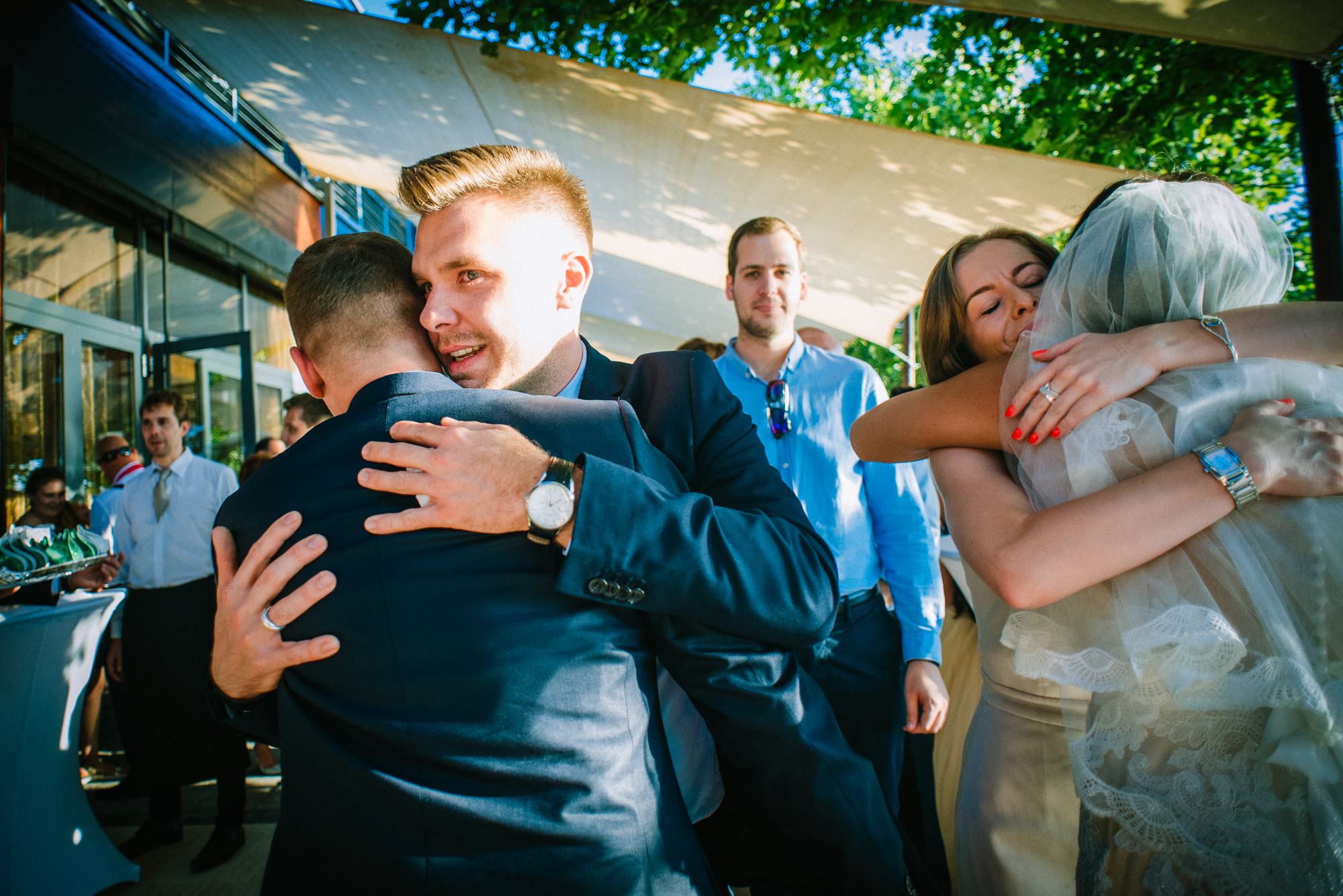 Close emotional hug between wedding guests with candid expressions during celebration.