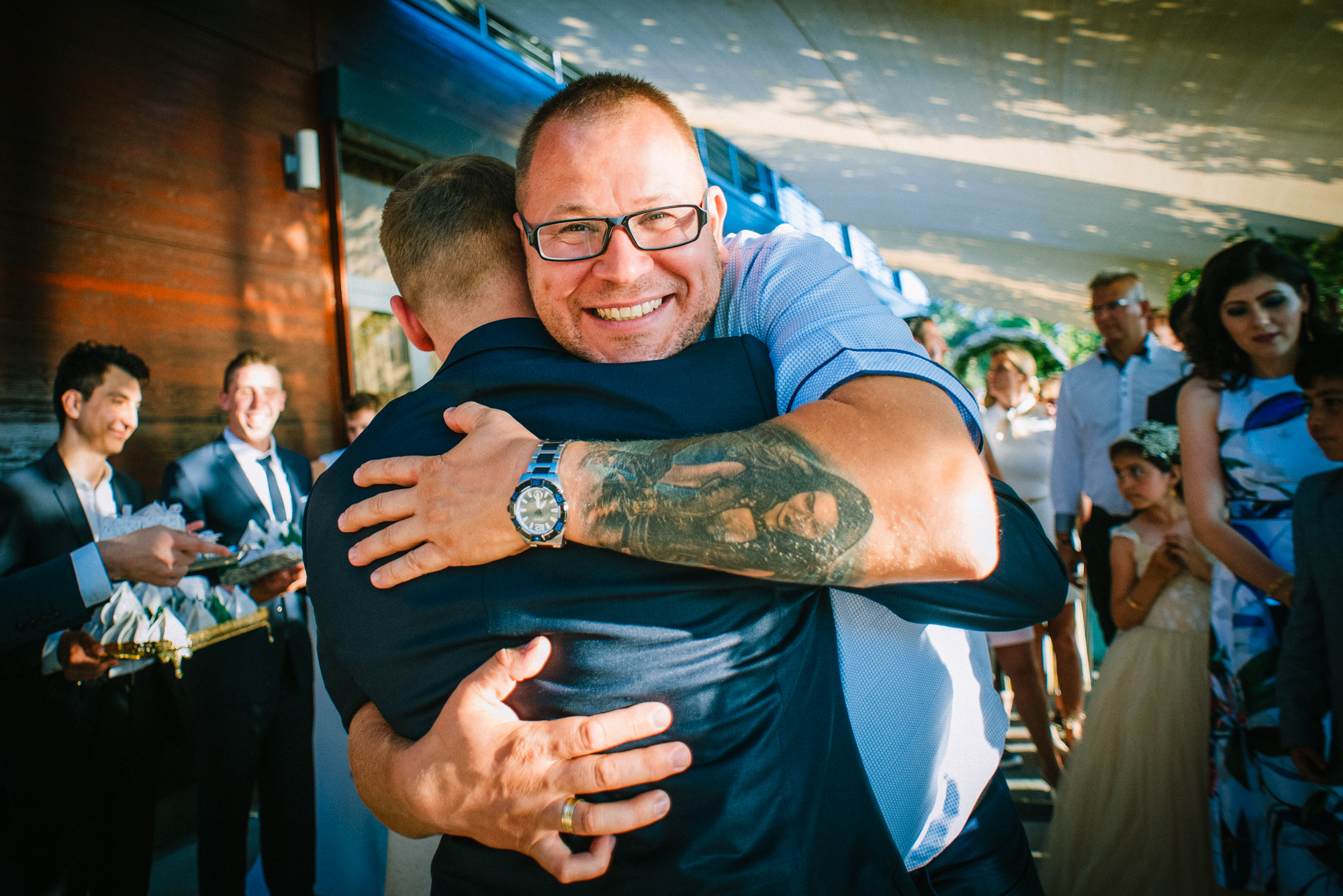 Guests embracing and greeting each other during relaxed outdoor Budapest wedding reception.