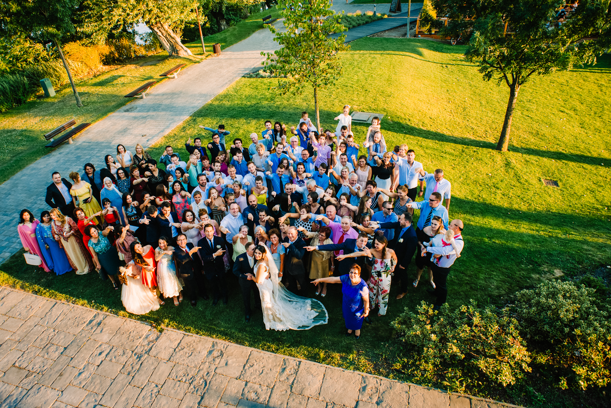Large group photo of wedding guests gathered outdoors at Öbölház Budapest venue.