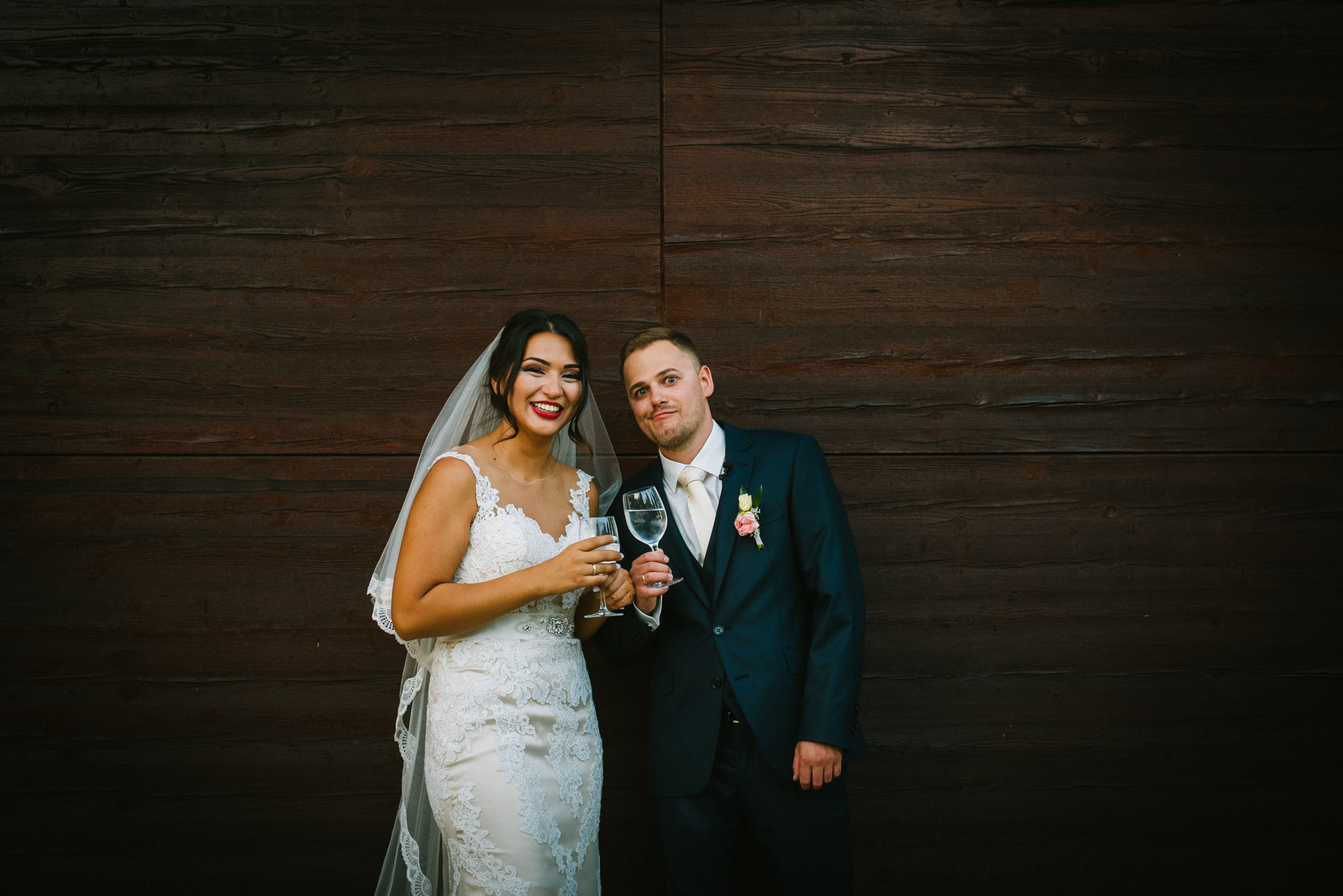 Bride and groom in front of wooden wall during Budapest wedding portraits.