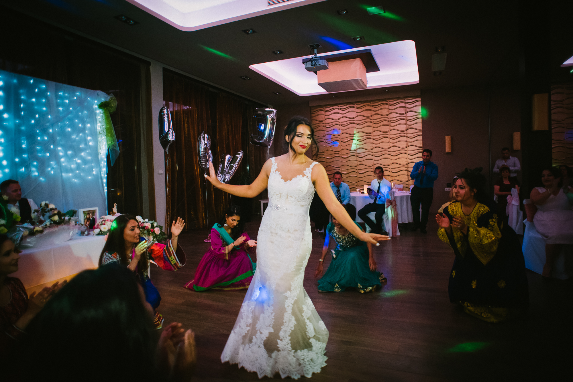 Bride dancing in lace dress surrounded by guests during lively Budapest wedding reception.