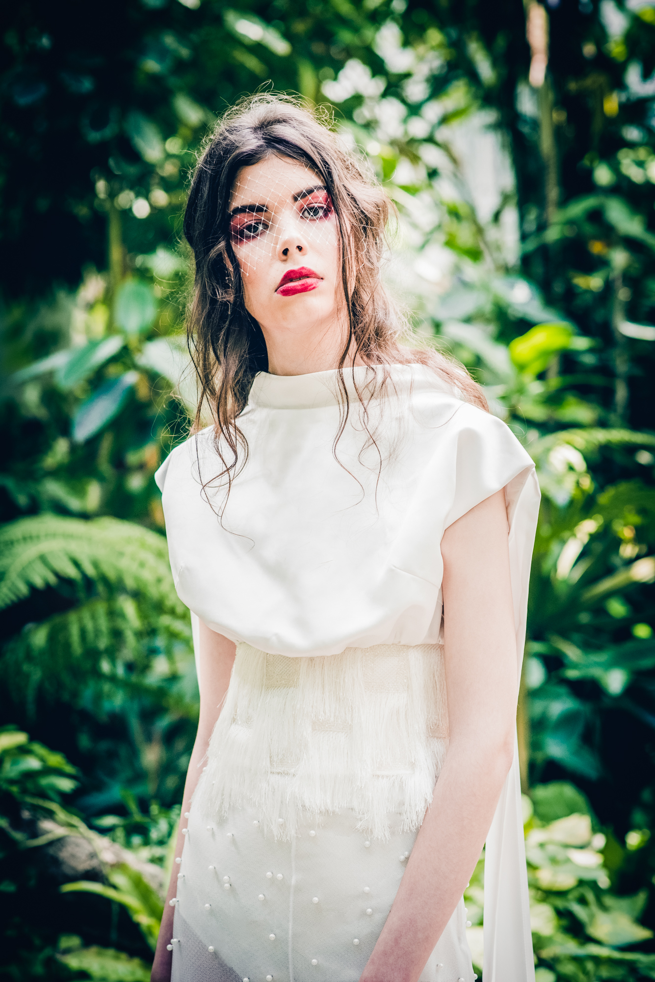 Bridal portrait in high-neck dress with soft textures in ELTE Botanical Garden setting.