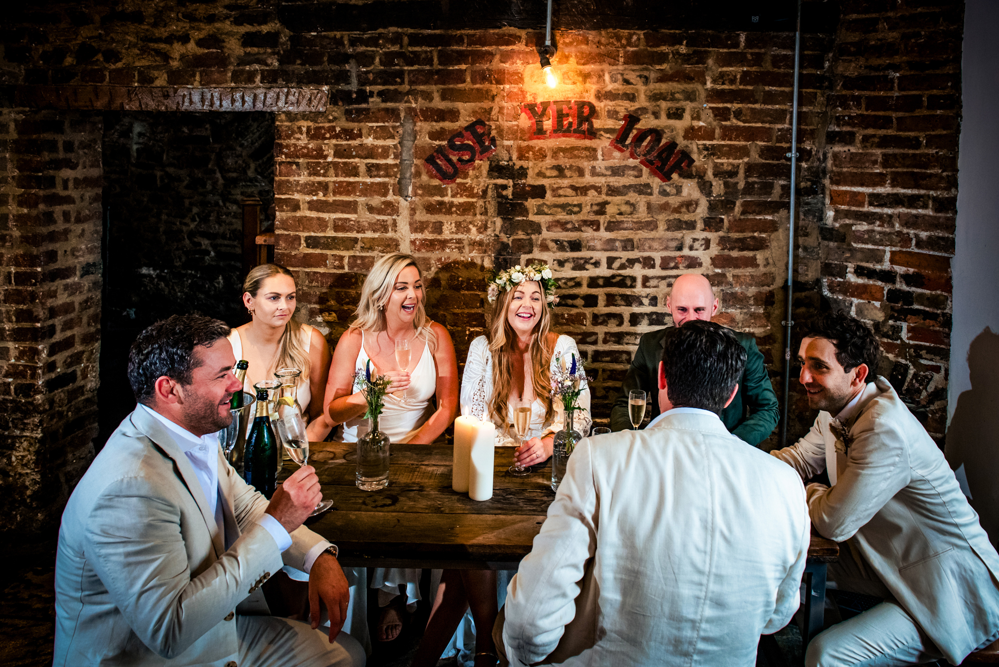 Friends gathered around table sharing drinks and laughter in warm candlelit space at the Christmas Steps Pub.