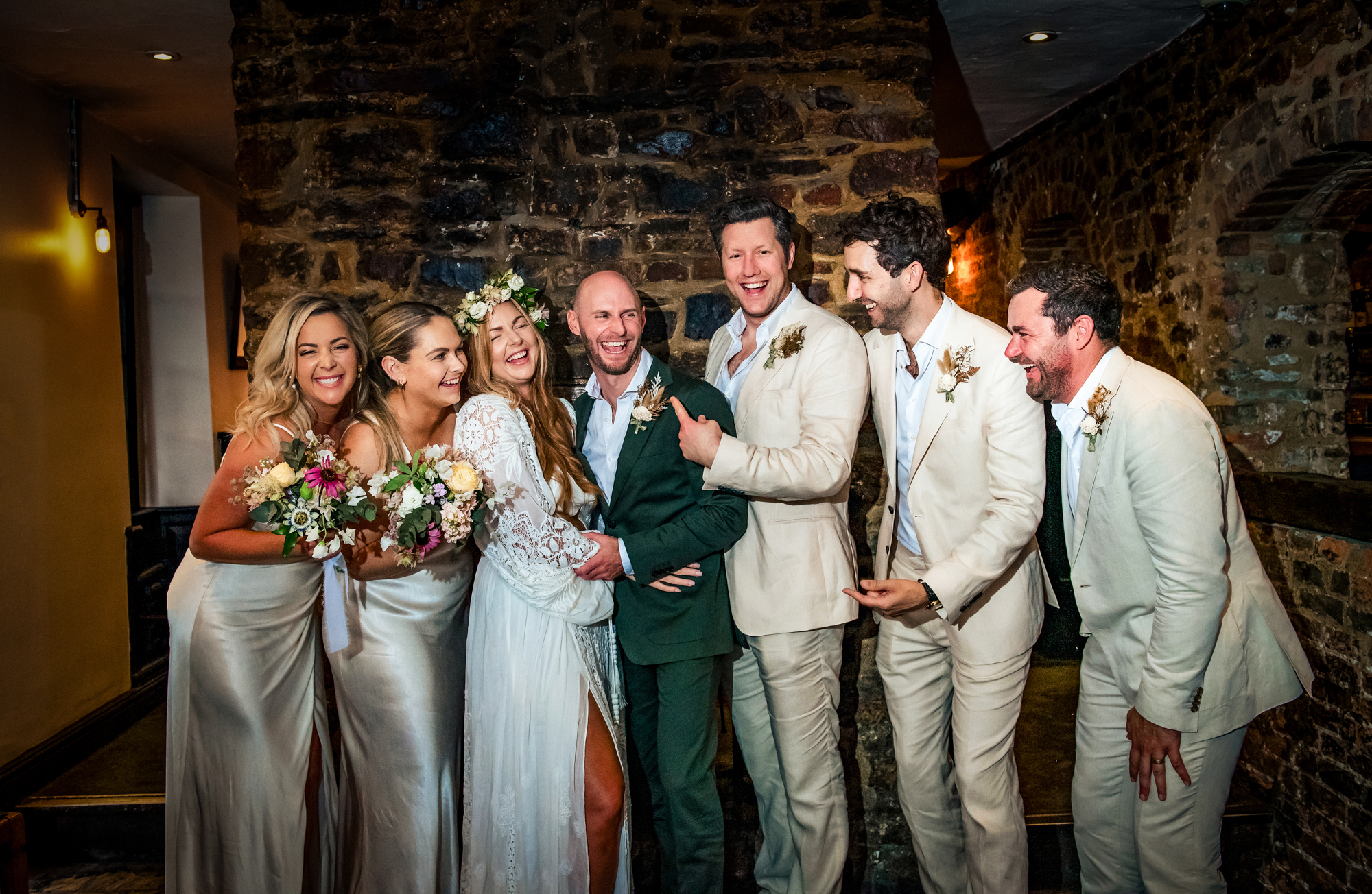 Wedding group portrait with bride and groom surrounded by their friends at the Christmas Steps Pub.