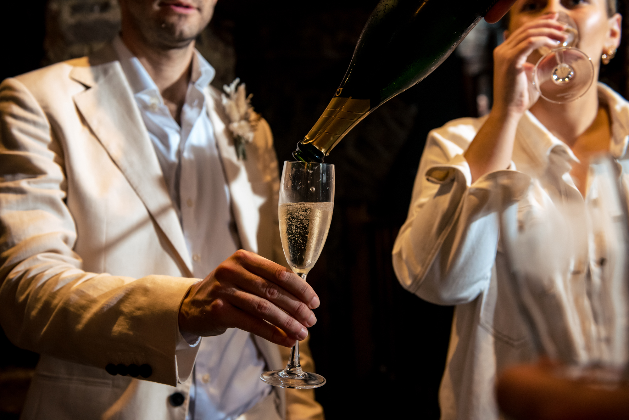 Close-up of champagne being poured during candid wedding celebration moment.