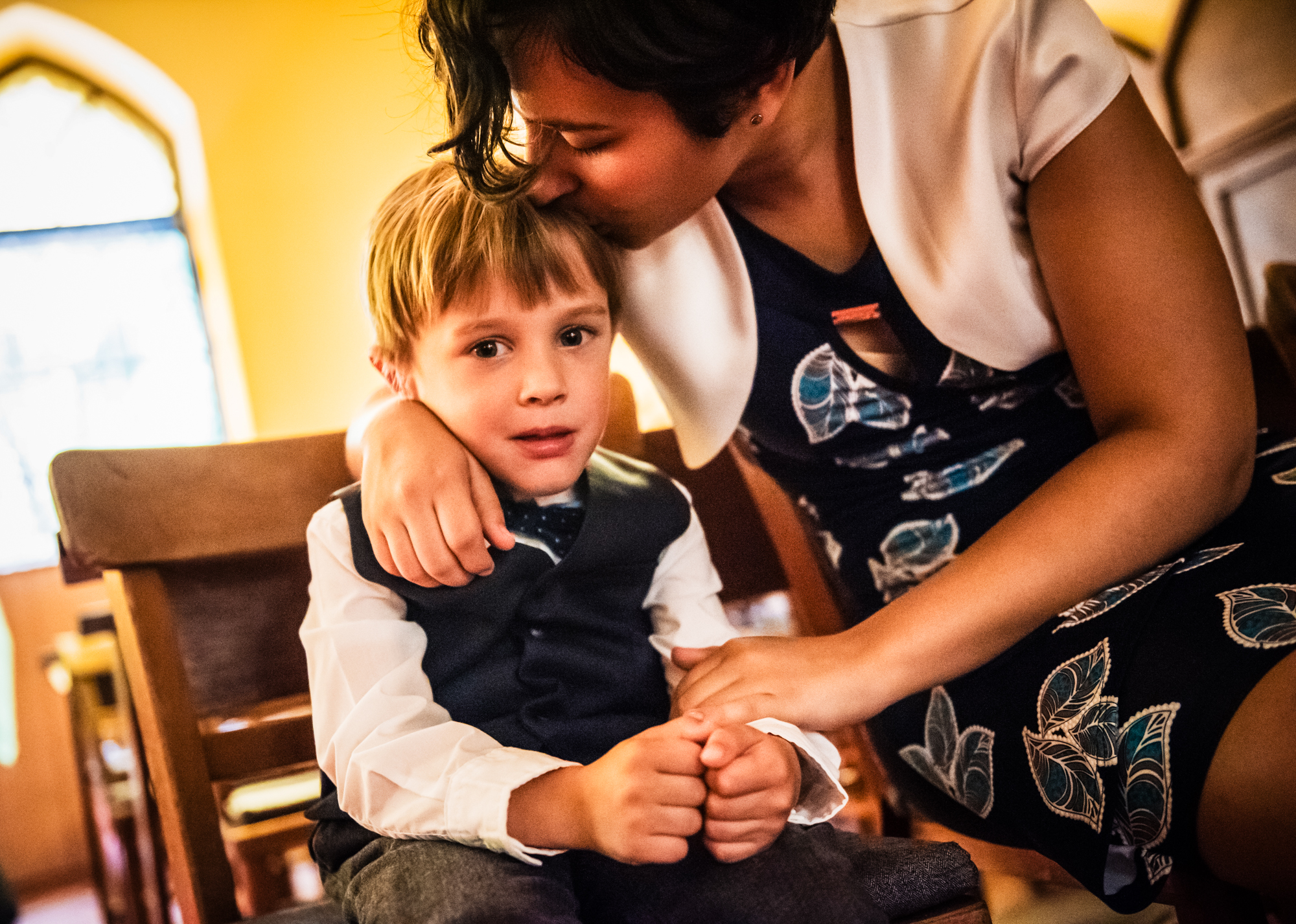 Guest kissing the boy before the church christening ceremony begins.