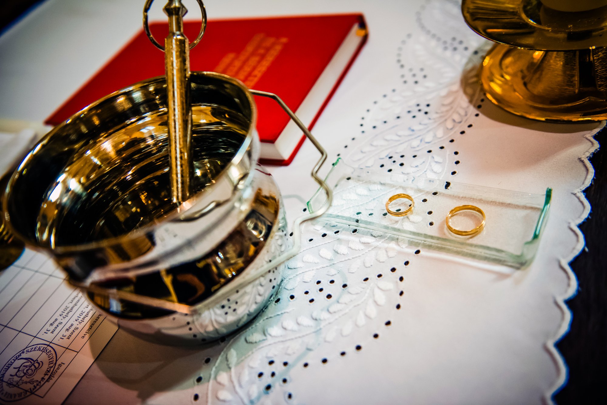 Wedding rings and holy water bowl prepared for a church christening ceremony.