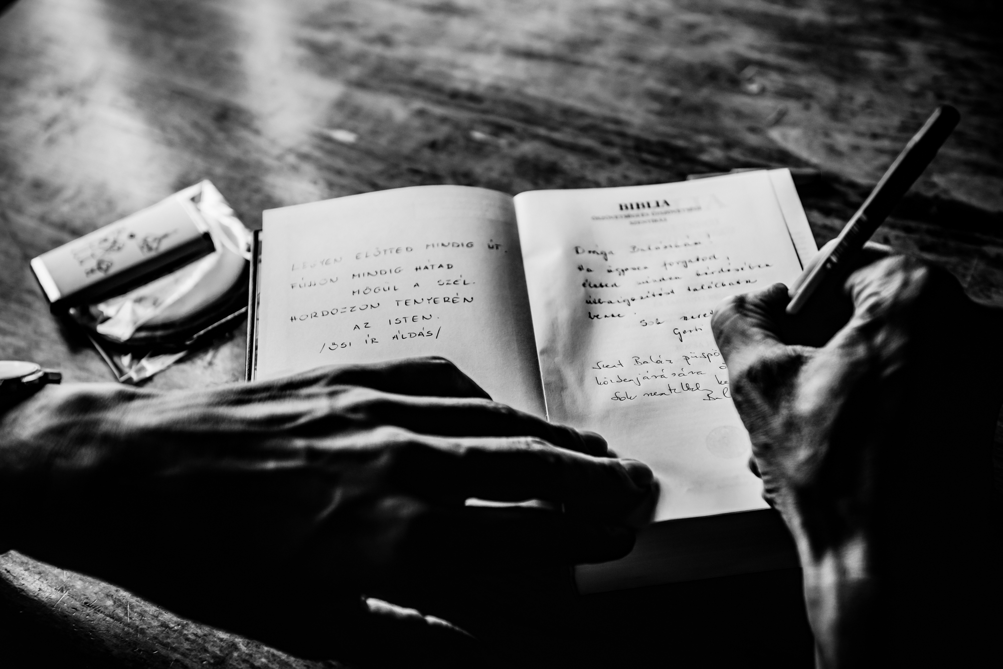 Close-up of handwritten messages inside family Bible during church christening gathering.