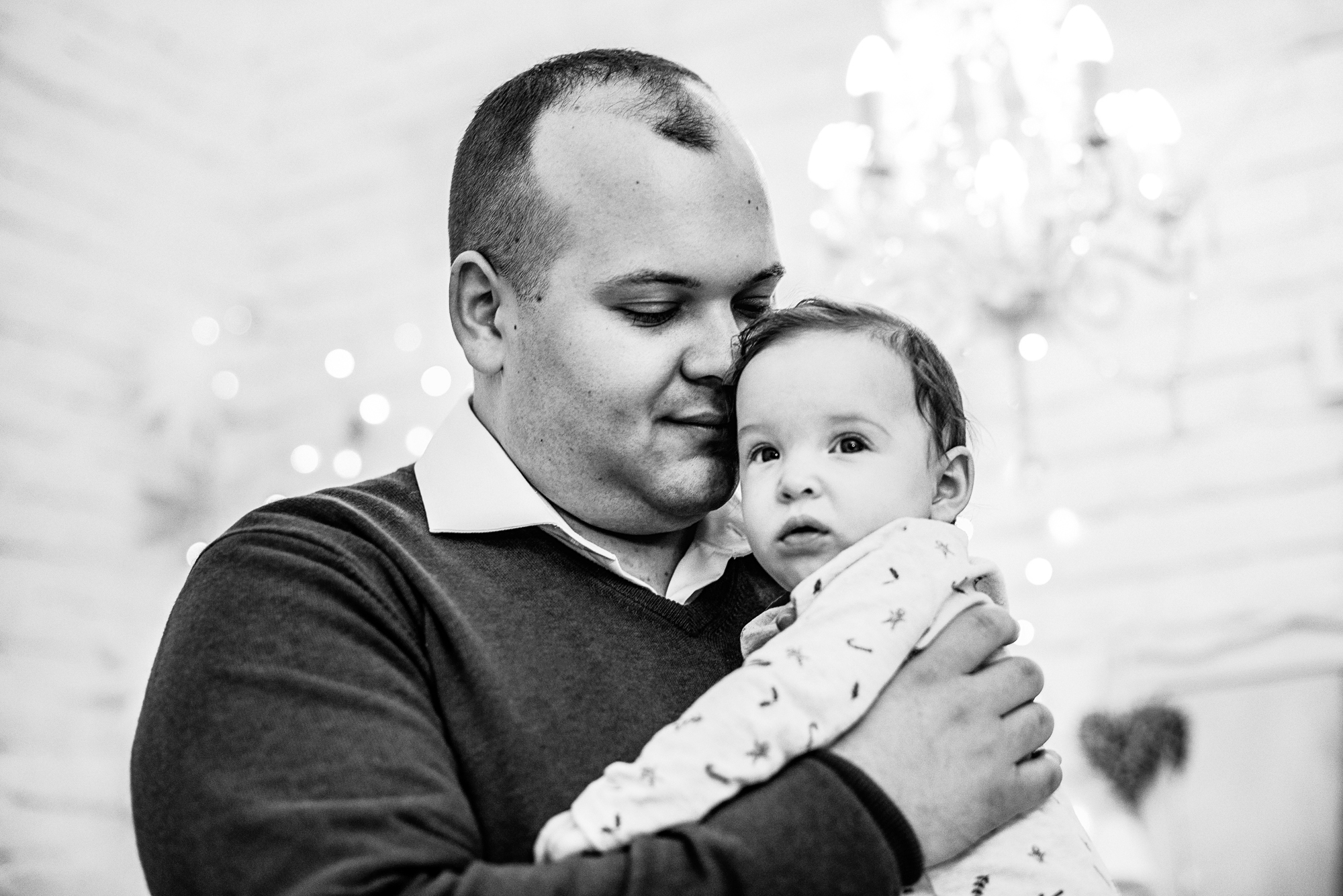 Father cuddles baby Bella close during a Christmas family photo session in the studio.