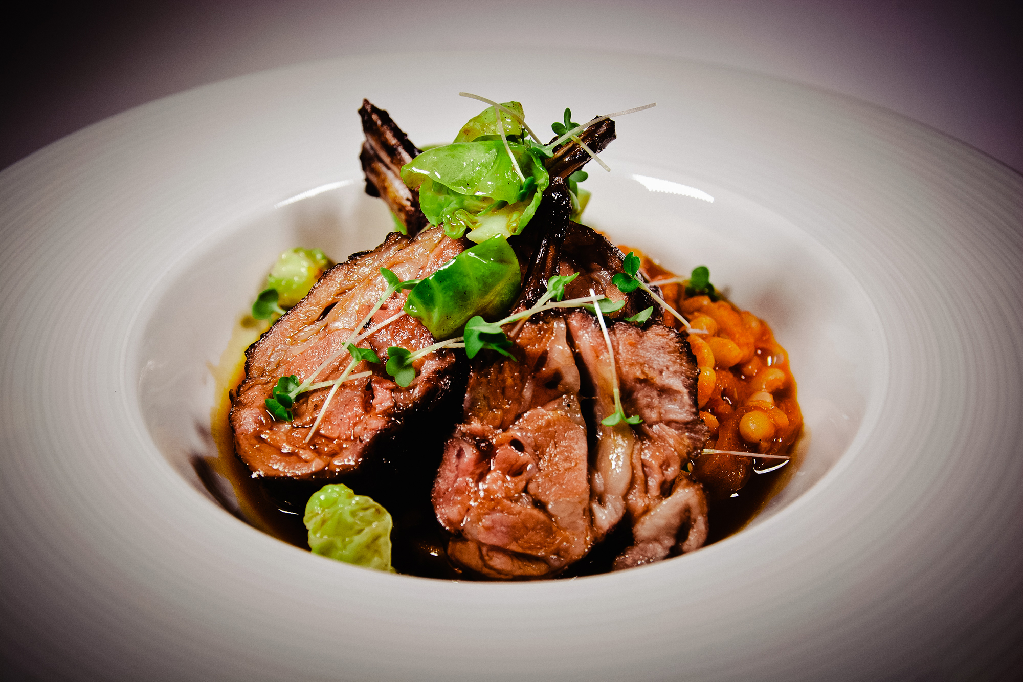 Slow-cooked meat dish with sprouts and rich sauce at Fricska Gastropub restaurant.